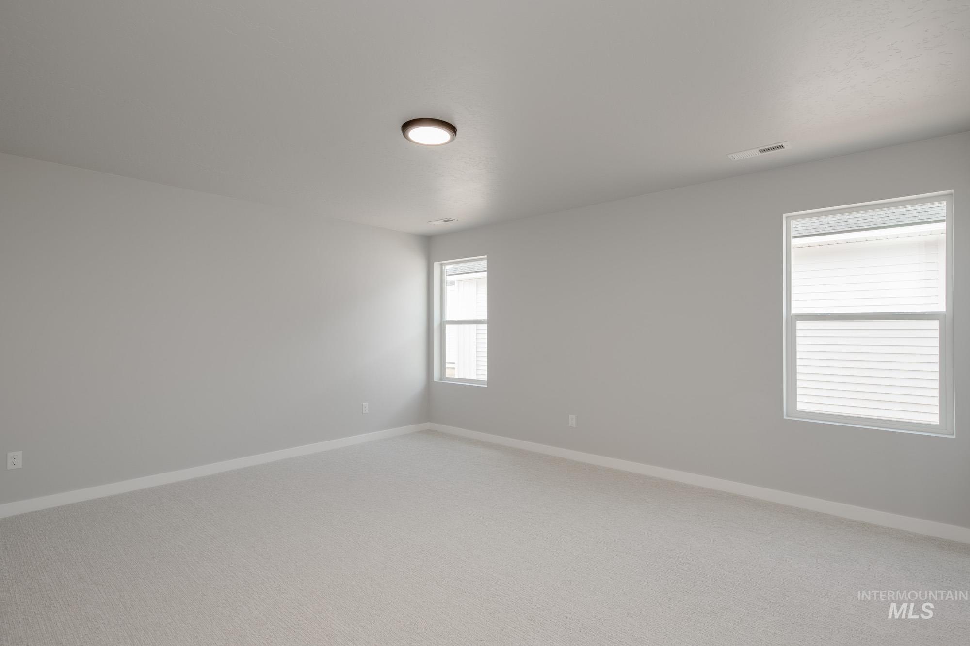 Carpeted spare room with baseboards