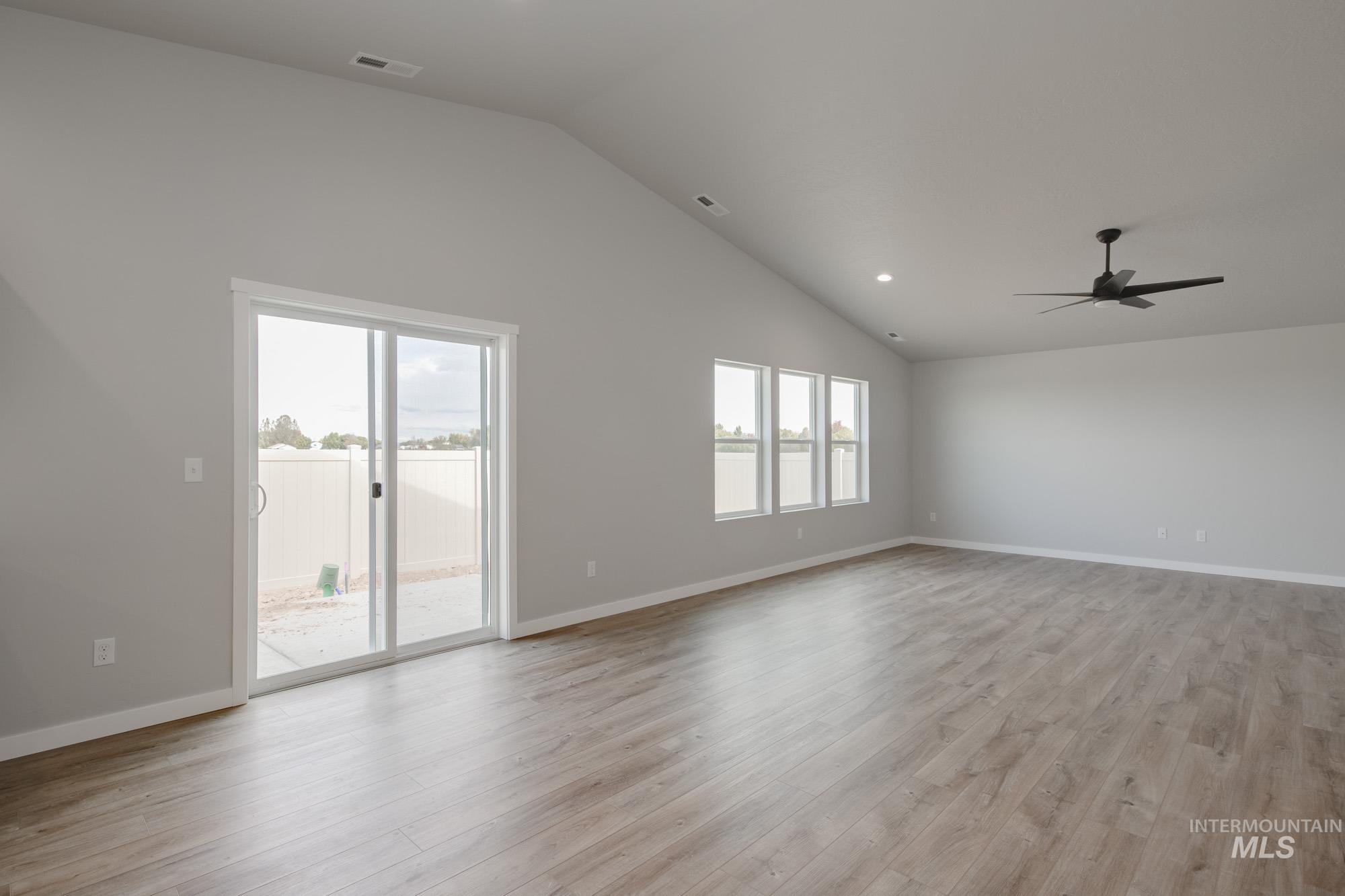 Unfurnished living room with vaulted ceiling, light wood finished floors, recessed lighting, and a ceiling fan