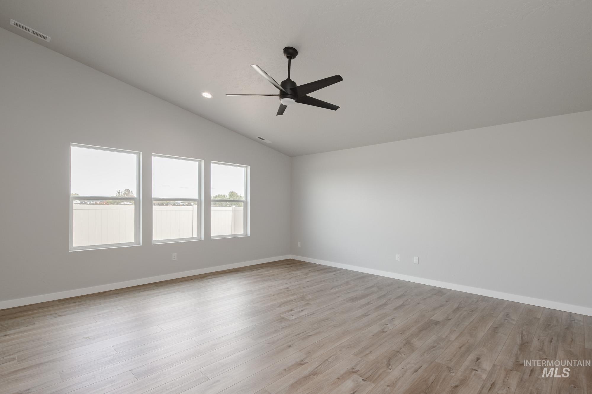 Unfurnished room with lofted ceiling, light wood-style floors, recessed lighting, and ceiling fan