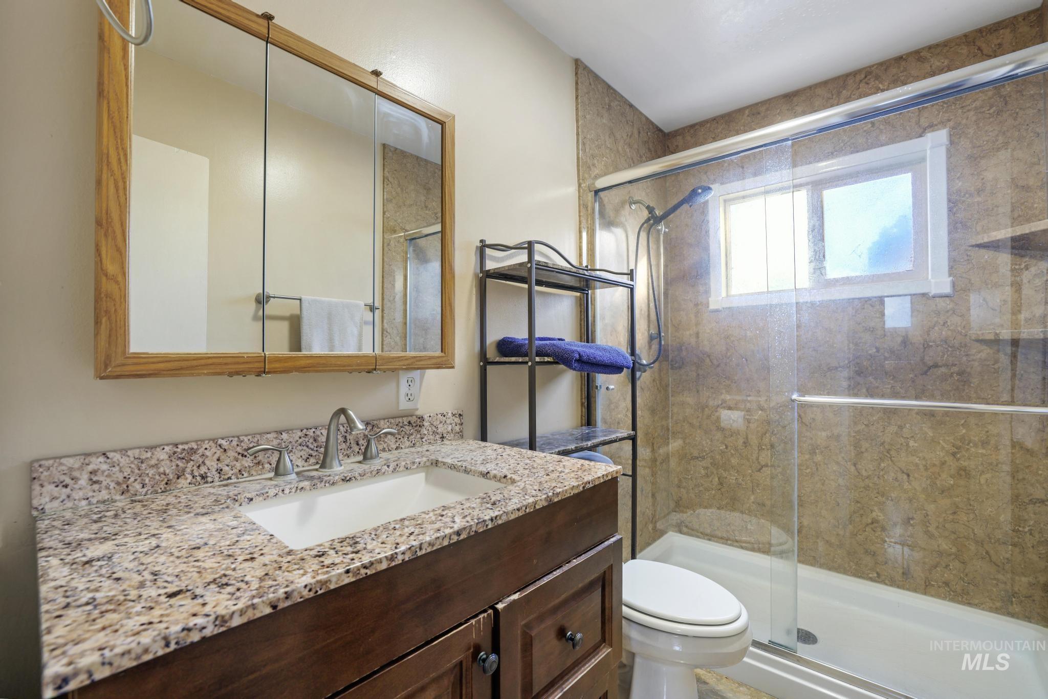 Full bath featuring vanity and a shower stall