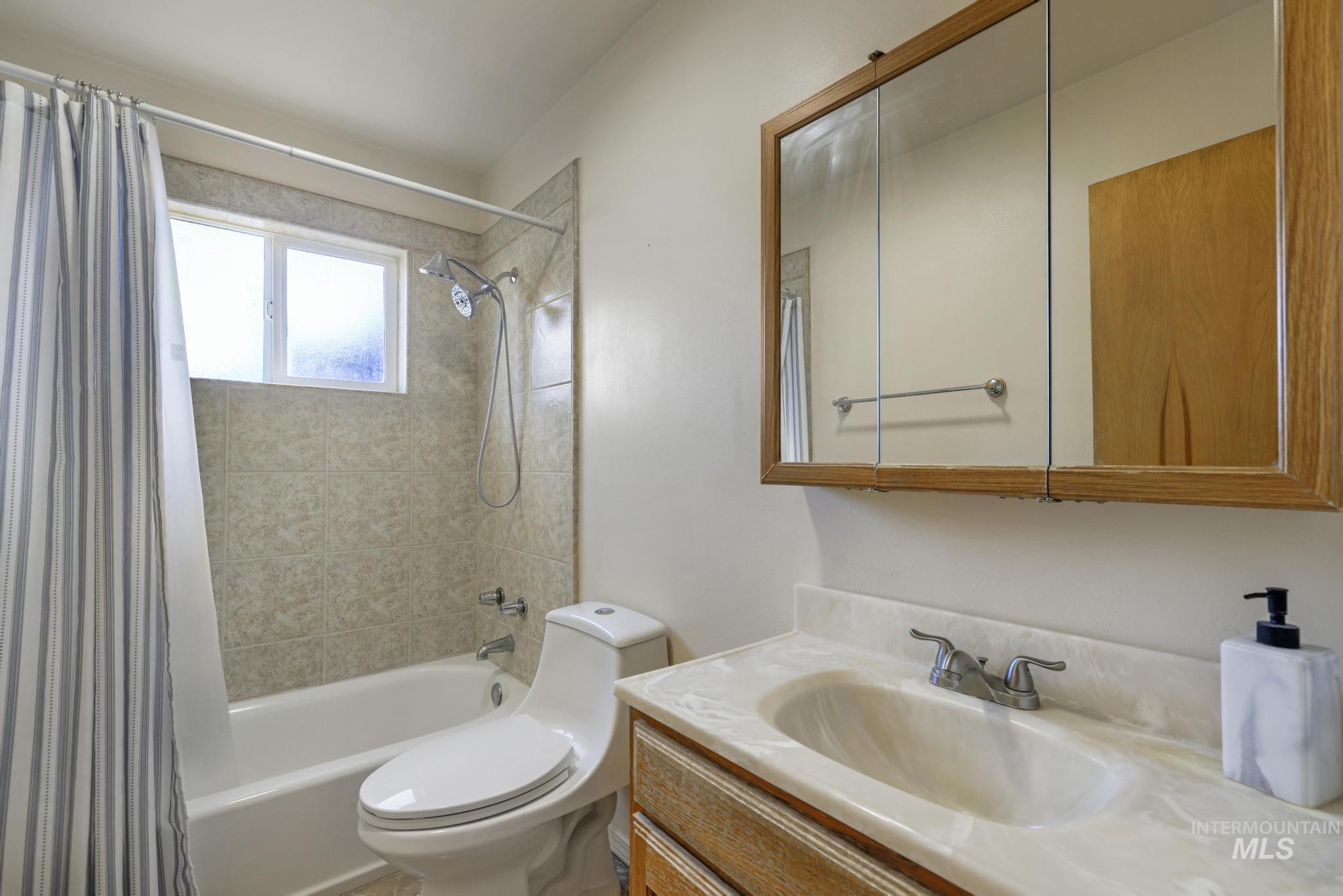 Bathroom with shower / tub combo with curtain and vanity