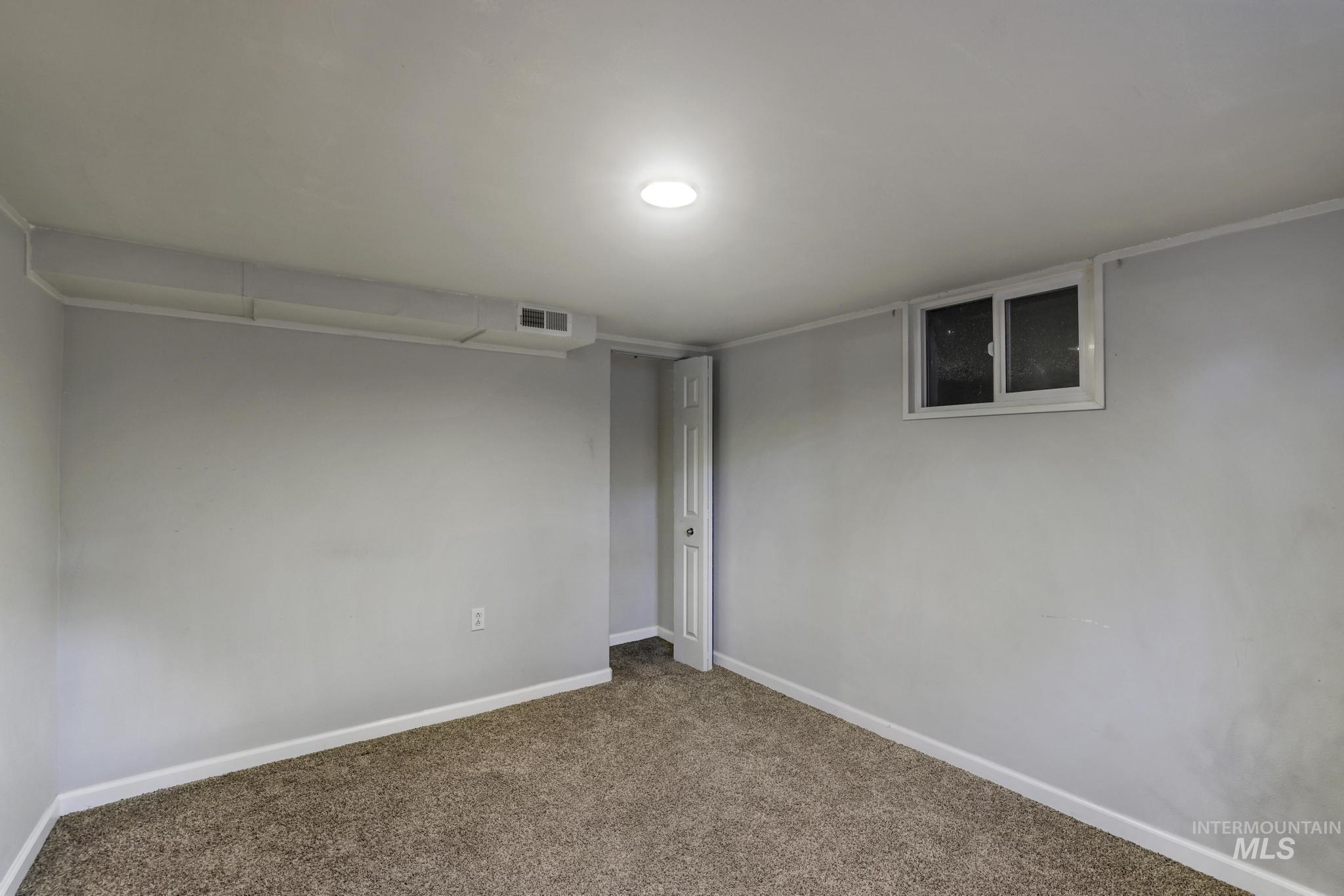 Spare room with baseboards and carpet