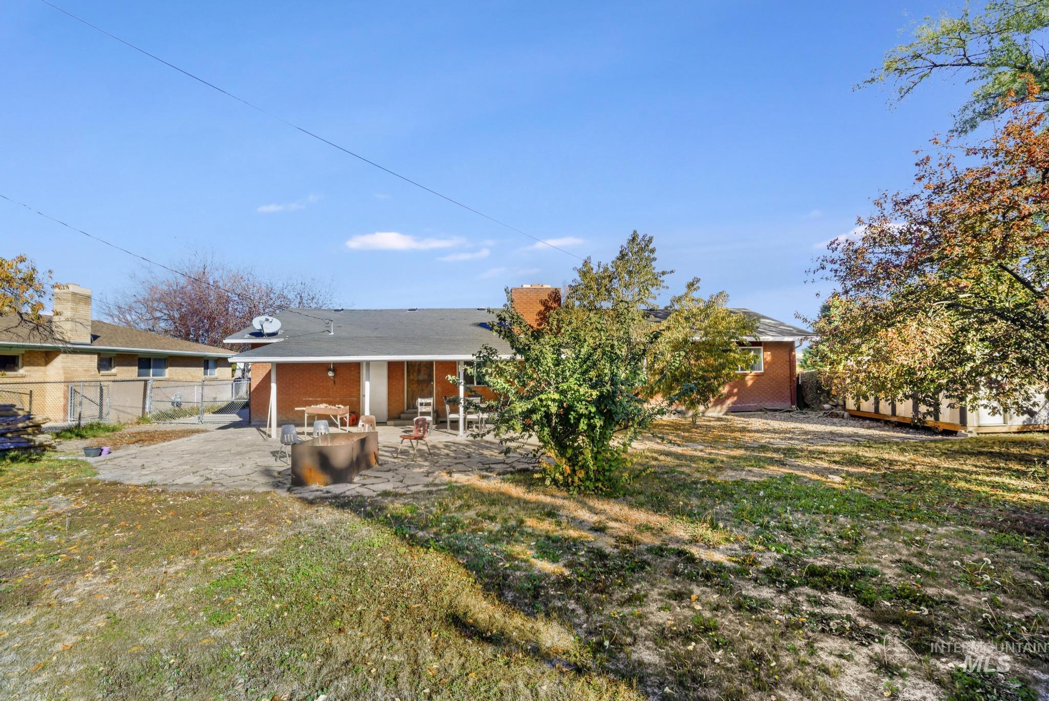Rear view of property featuring a fenced backyard, a patio, and brick siding
