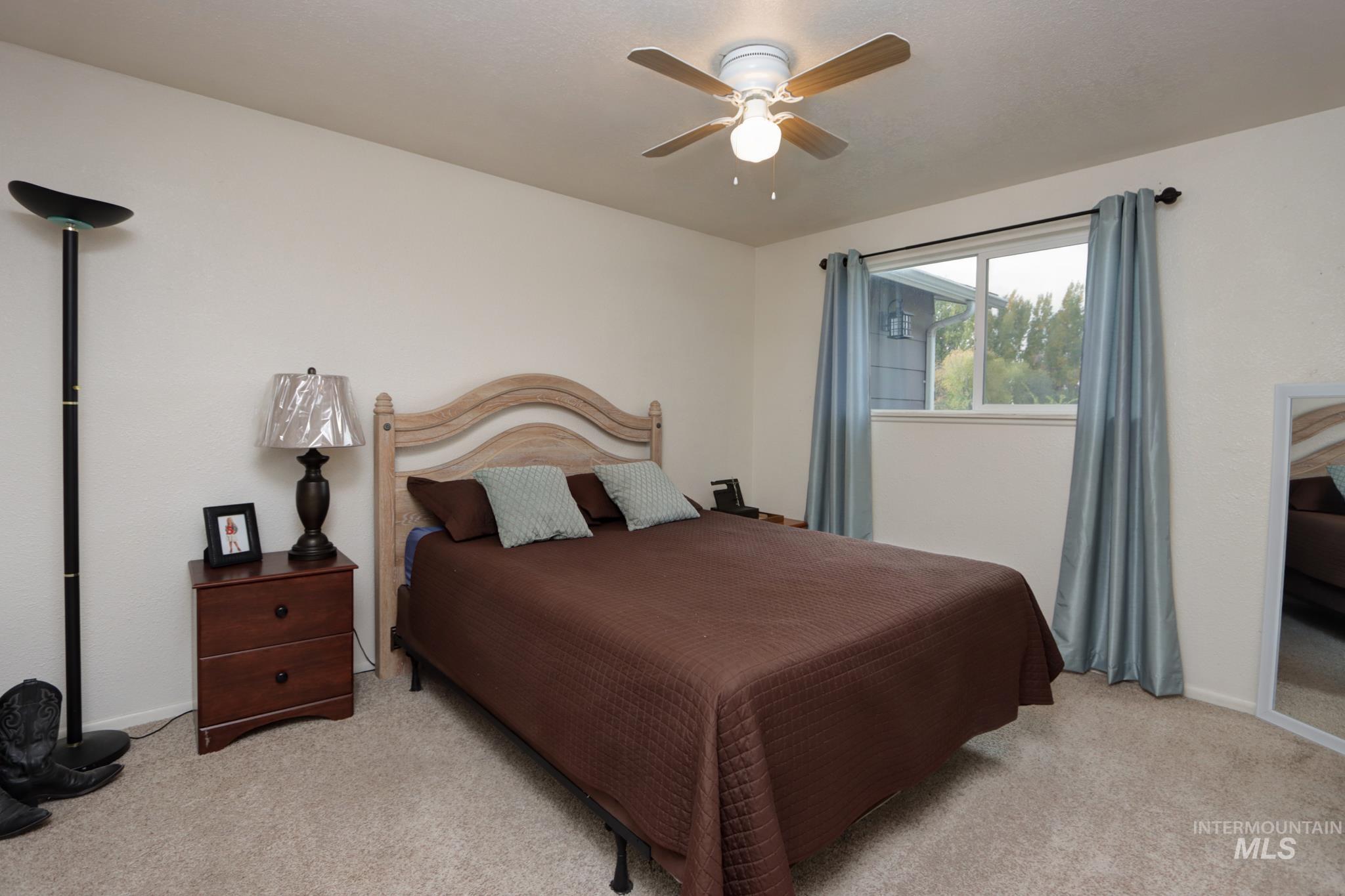 Bedroom featuring light colored carpet and a ceiling fan
