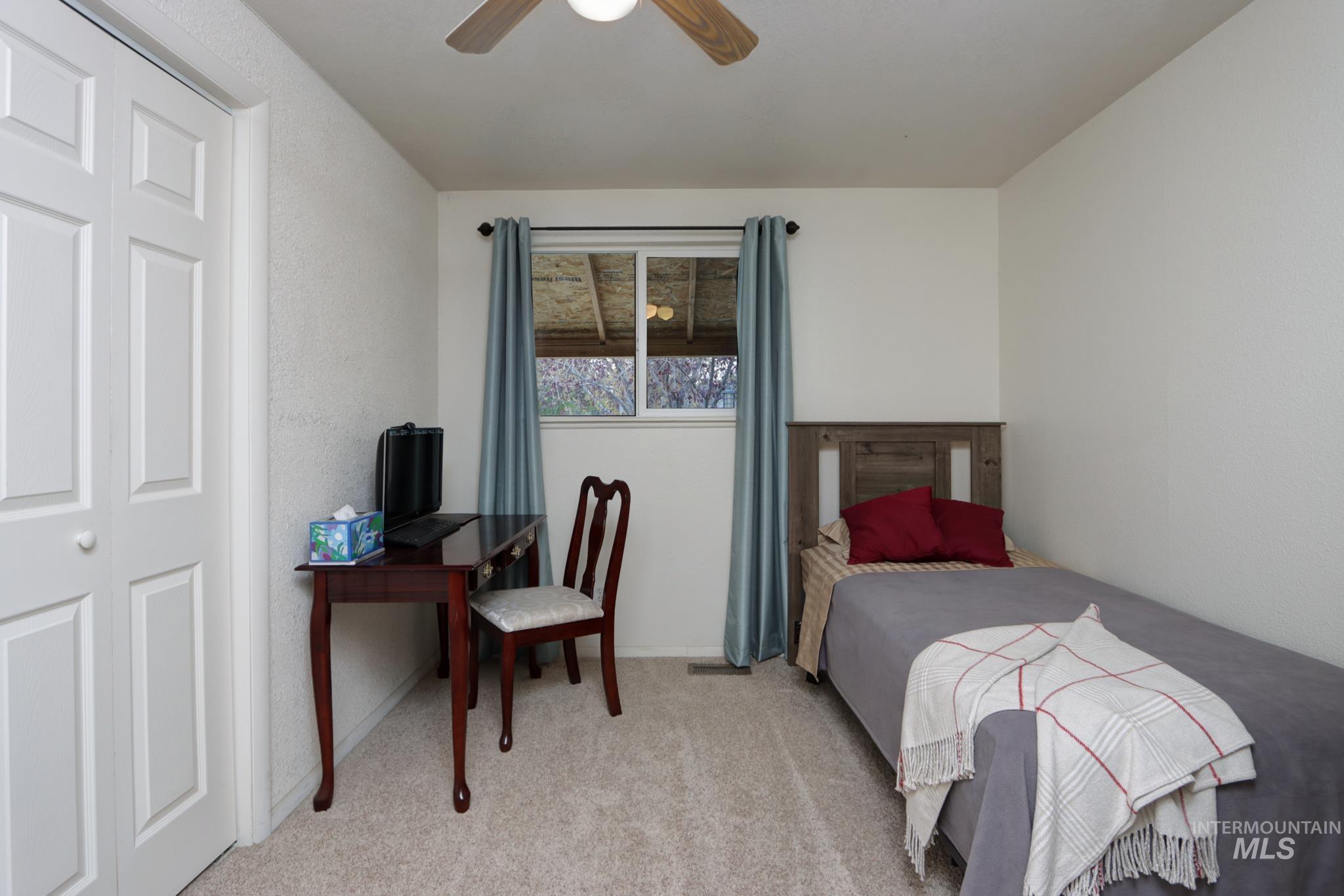 Bedroom with light colored carpet and ceiling fan