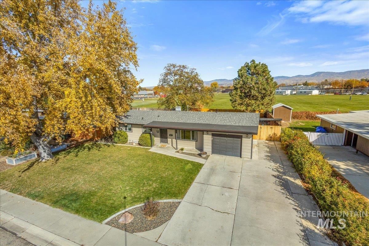 Single story home with concrete driveway, a garage, and a mountain view