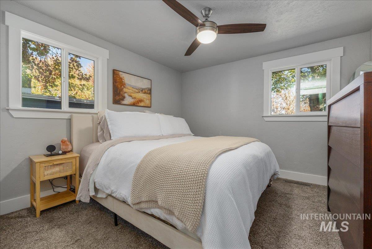 Carpeted bedroom with baseboards and a ceiling fan