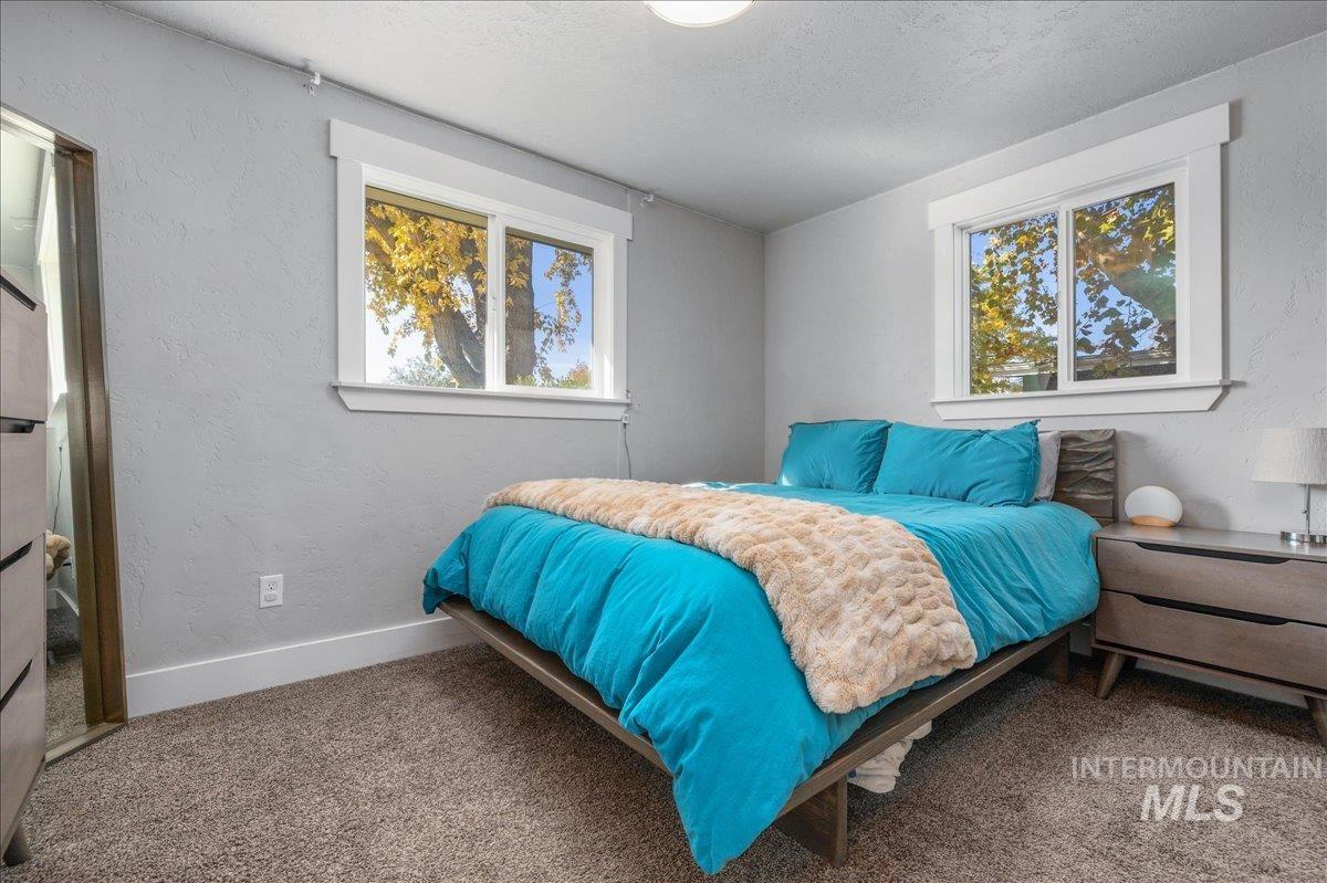 Carpeted bedroom with a textured wall and a textured ceiling