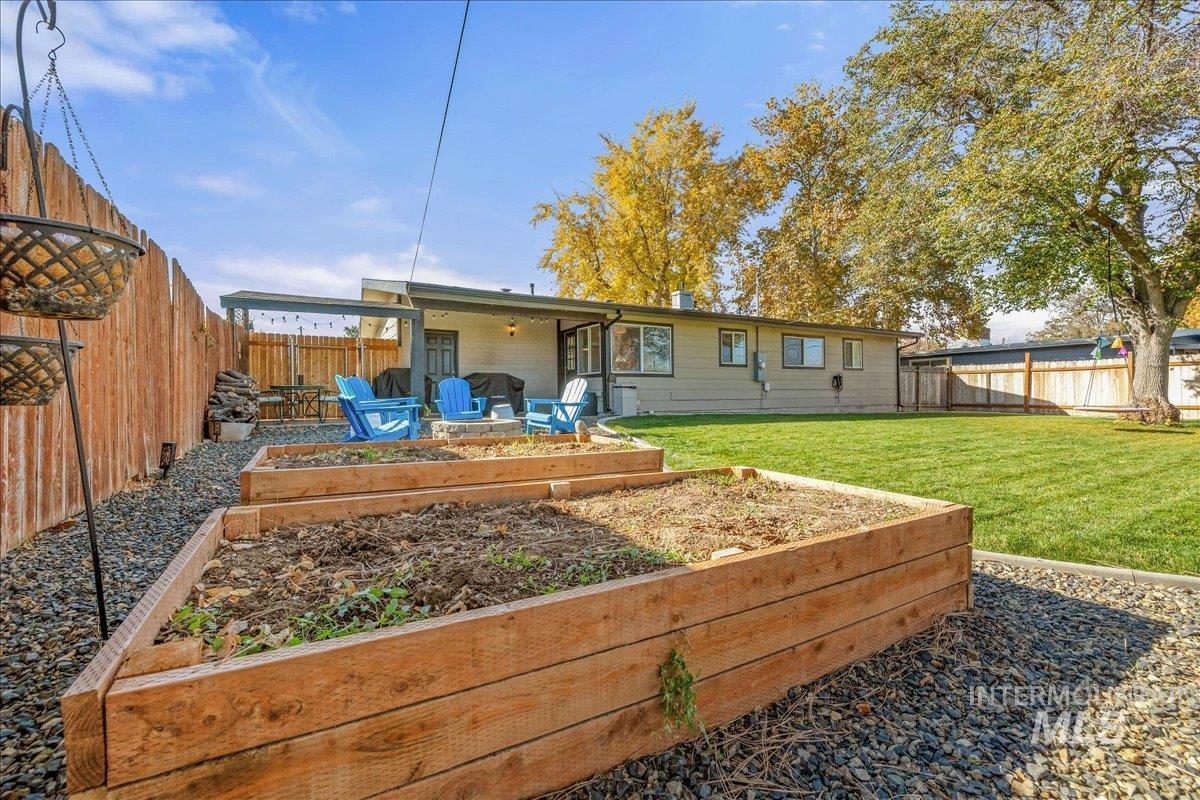 Back of house with a vegetable garden, a fenced backyard, and a patio area
