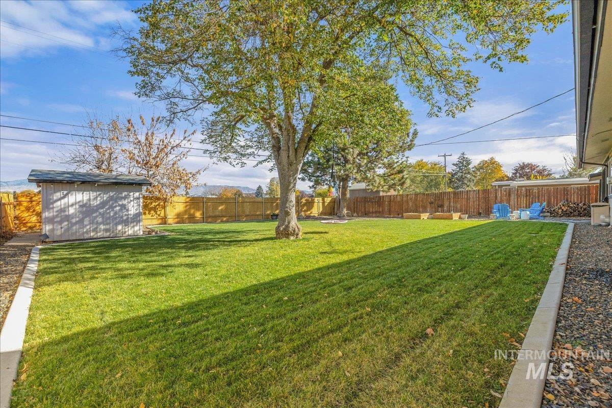 Fenced backyard with an outbuilding and a patio