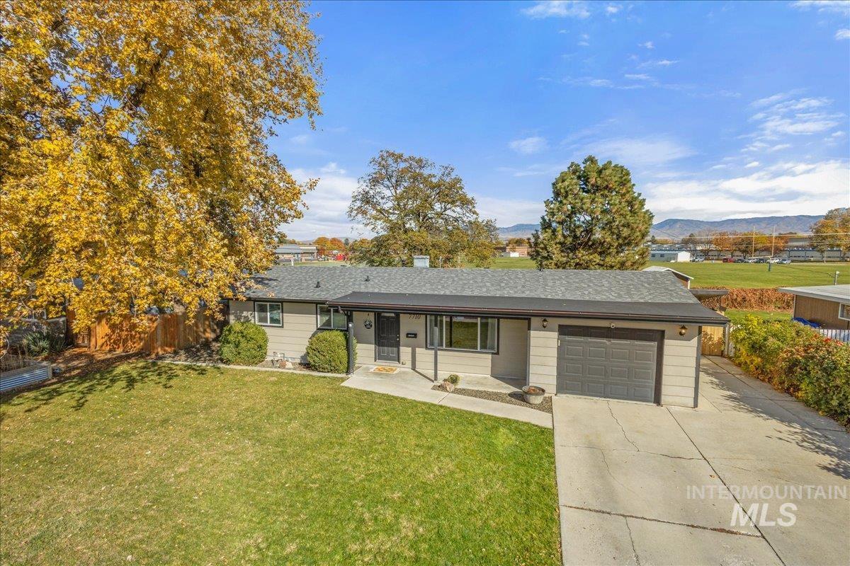Single story home featuring an attached garage, driveway, a mountain view, and roof with shingles