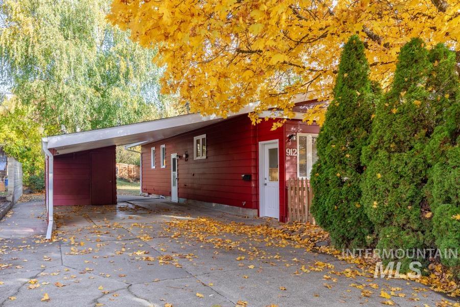 View of side of home with a carport and asphalt driveway