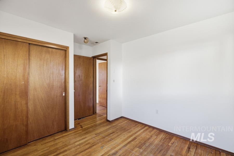 Unfurnished bedroom featuring wood finished floors and a closet