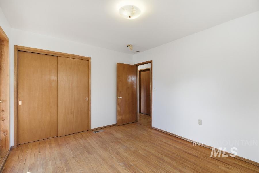 Unfurnished bedroom with light wood-style floors and a closet