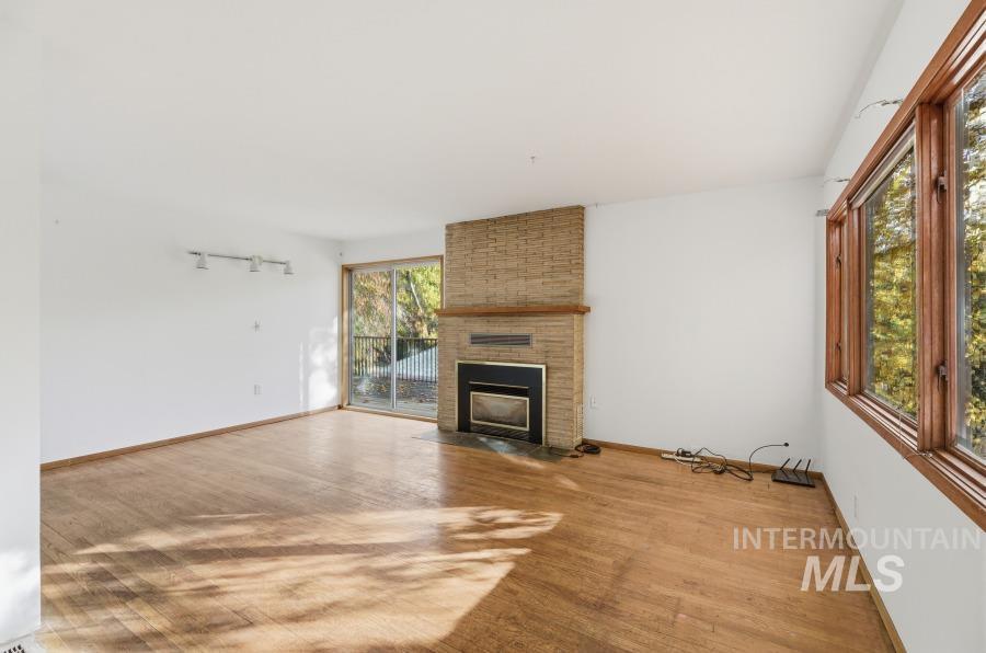 Unfurnished living room featuring a fireplace and light wood-style flooring
