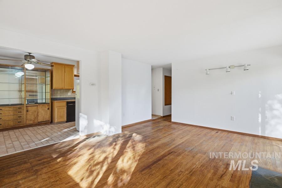 Unfurnished living room featuring wood finished floors and a ceiling fan