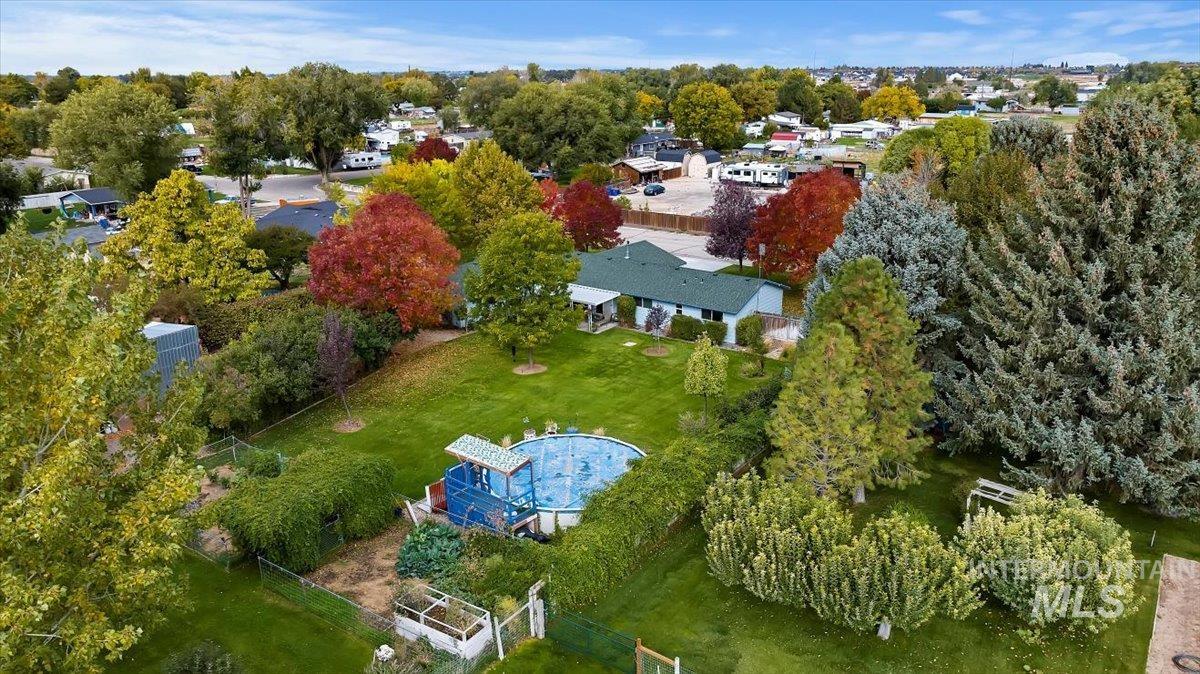 Aerial view of property and surrounding area with a tree filled landscape and a large body of water