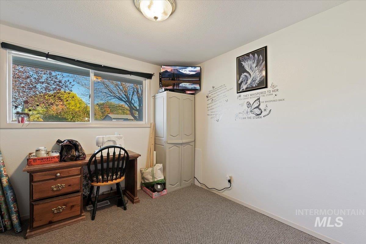 Home office with carpet and a textured ceiling