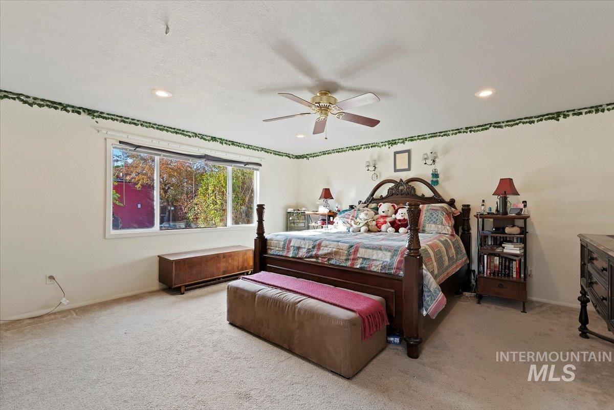 Bedroom featuring light colored carpet, ceiling fan, recessed lighting, and a textured ceiling
