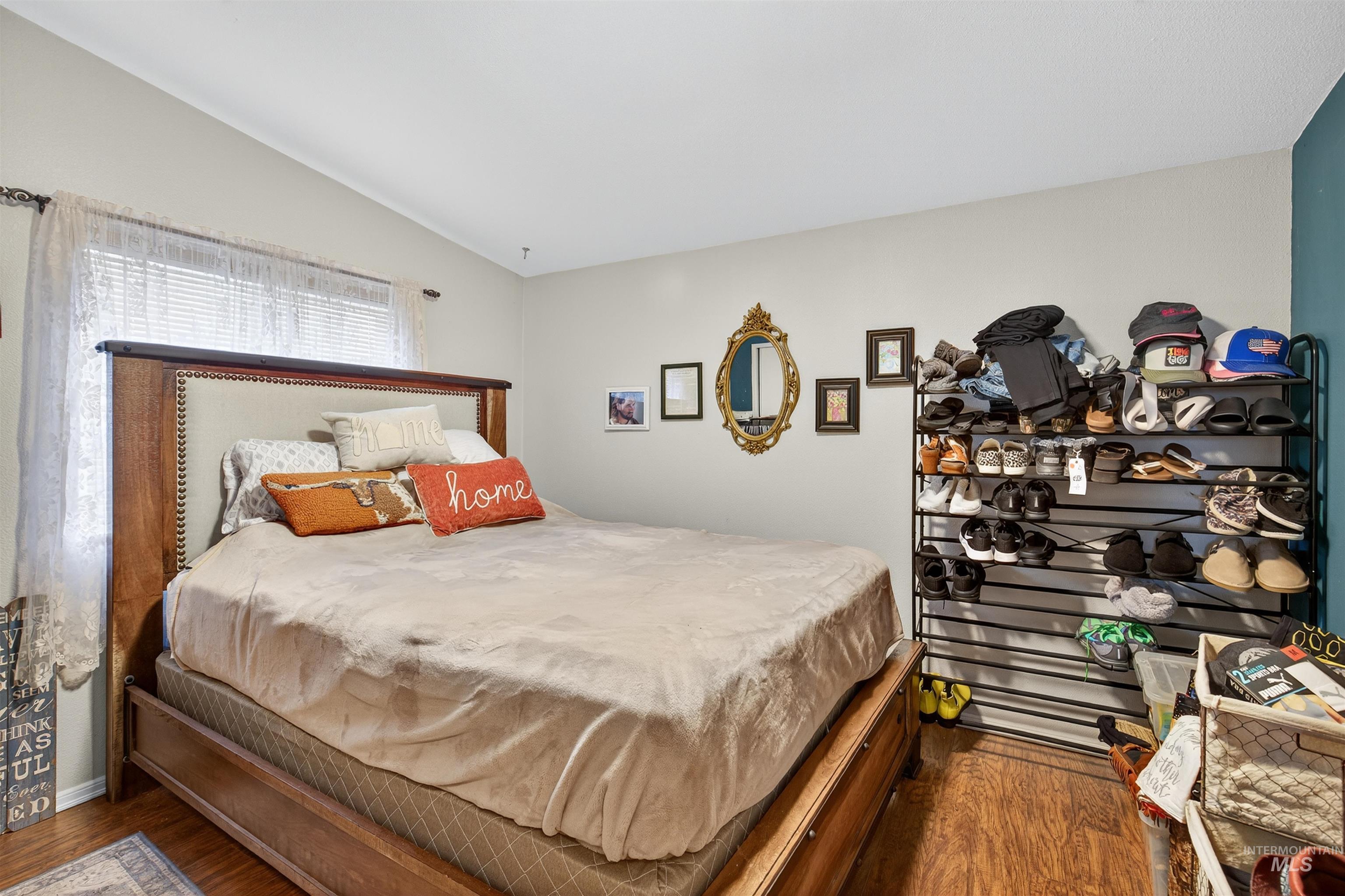 Bedroom with dark wood-style floors and lofted ceiling