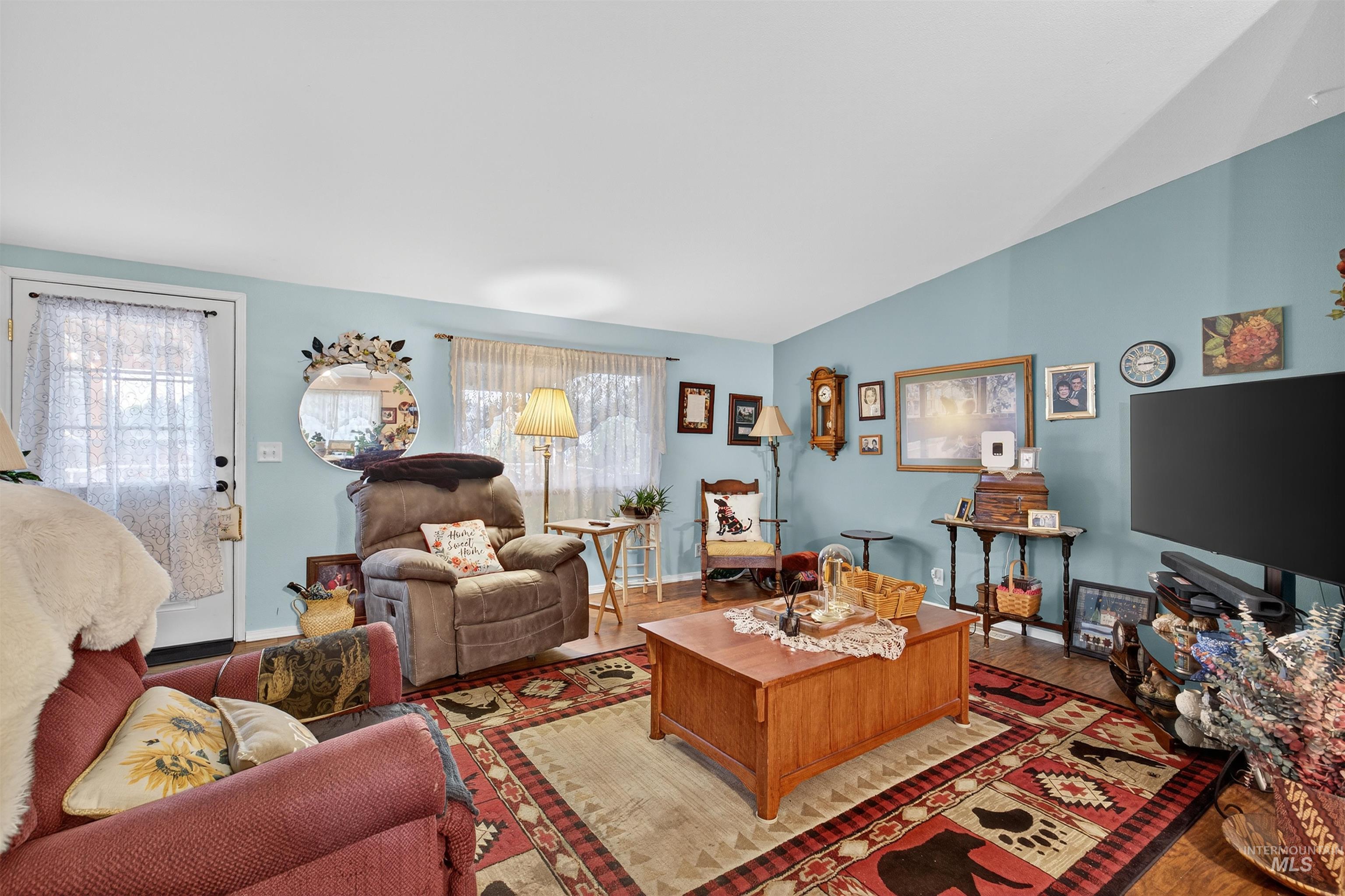 Living area featuring wood finished floors and vaulted ceiling