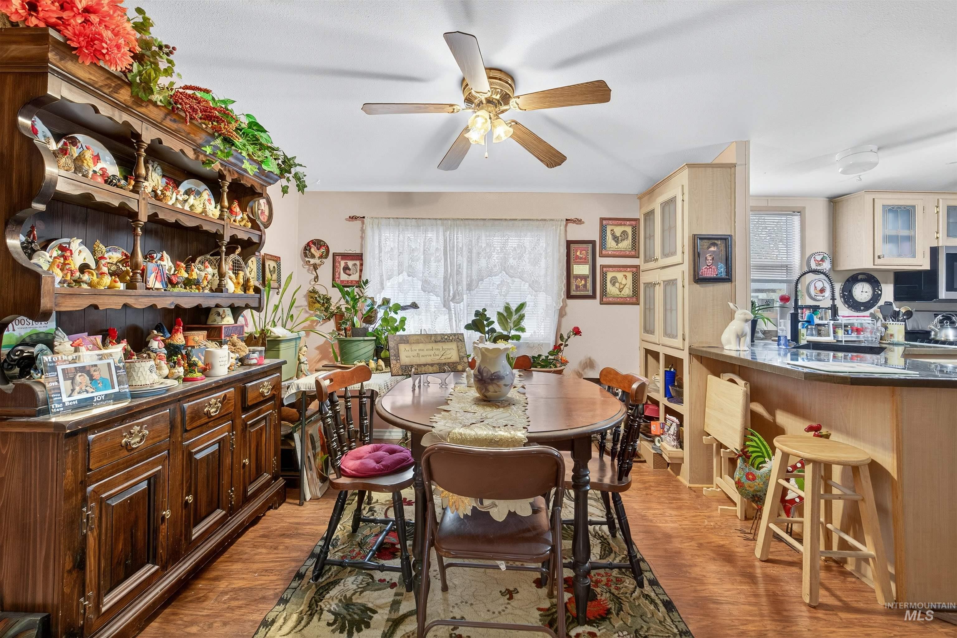Dining area with light wood-style floors and ceiling fan