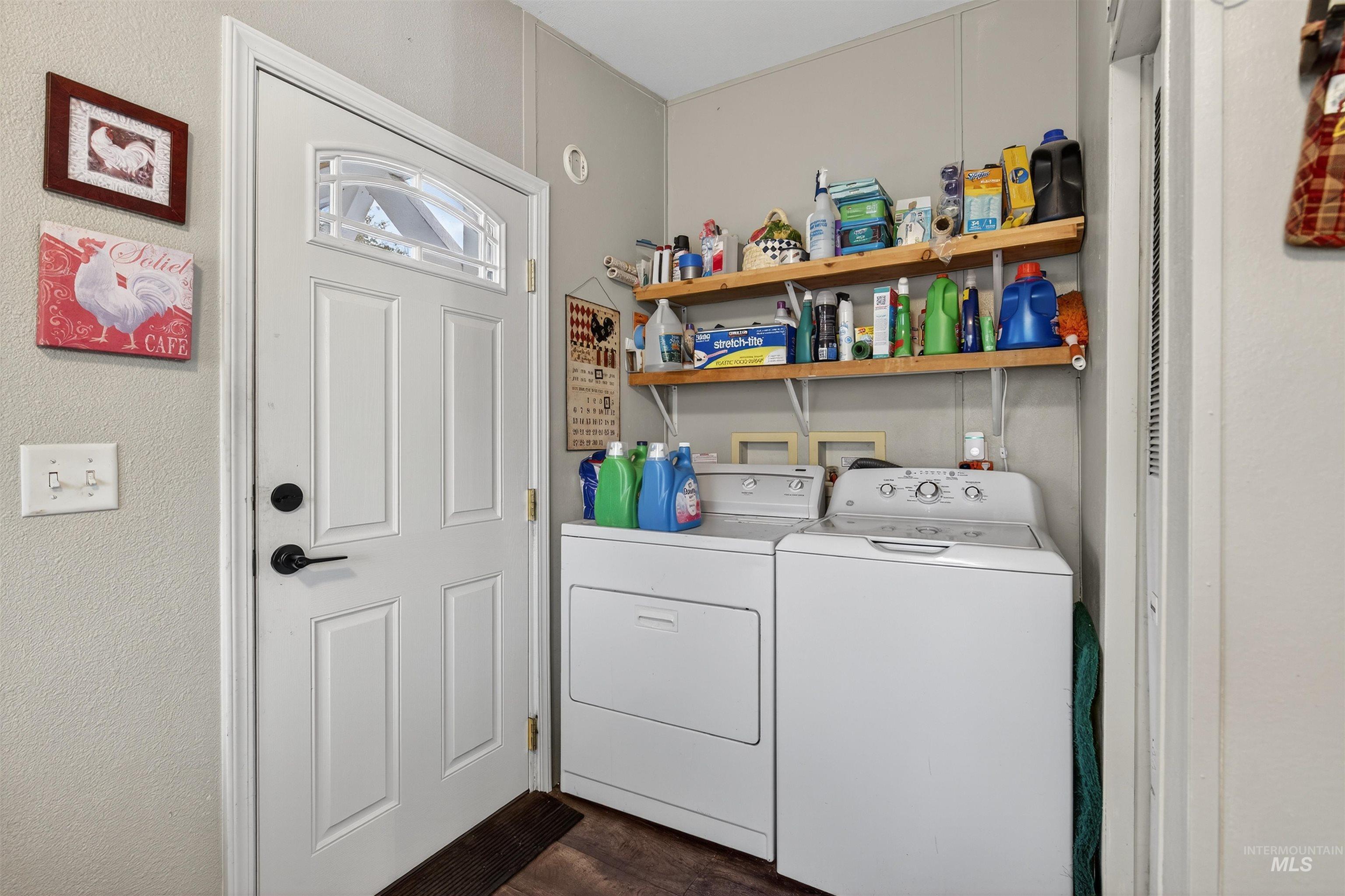 Laundry area with washing machine and clothes dryer, dark wood-type flooring, and a textured wall