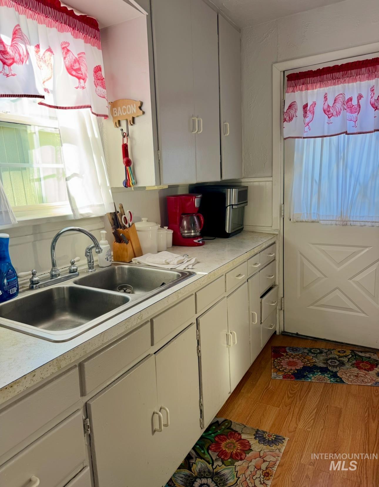 Kitchen featuring light countertops, light wood-style flooring, and white cabinets