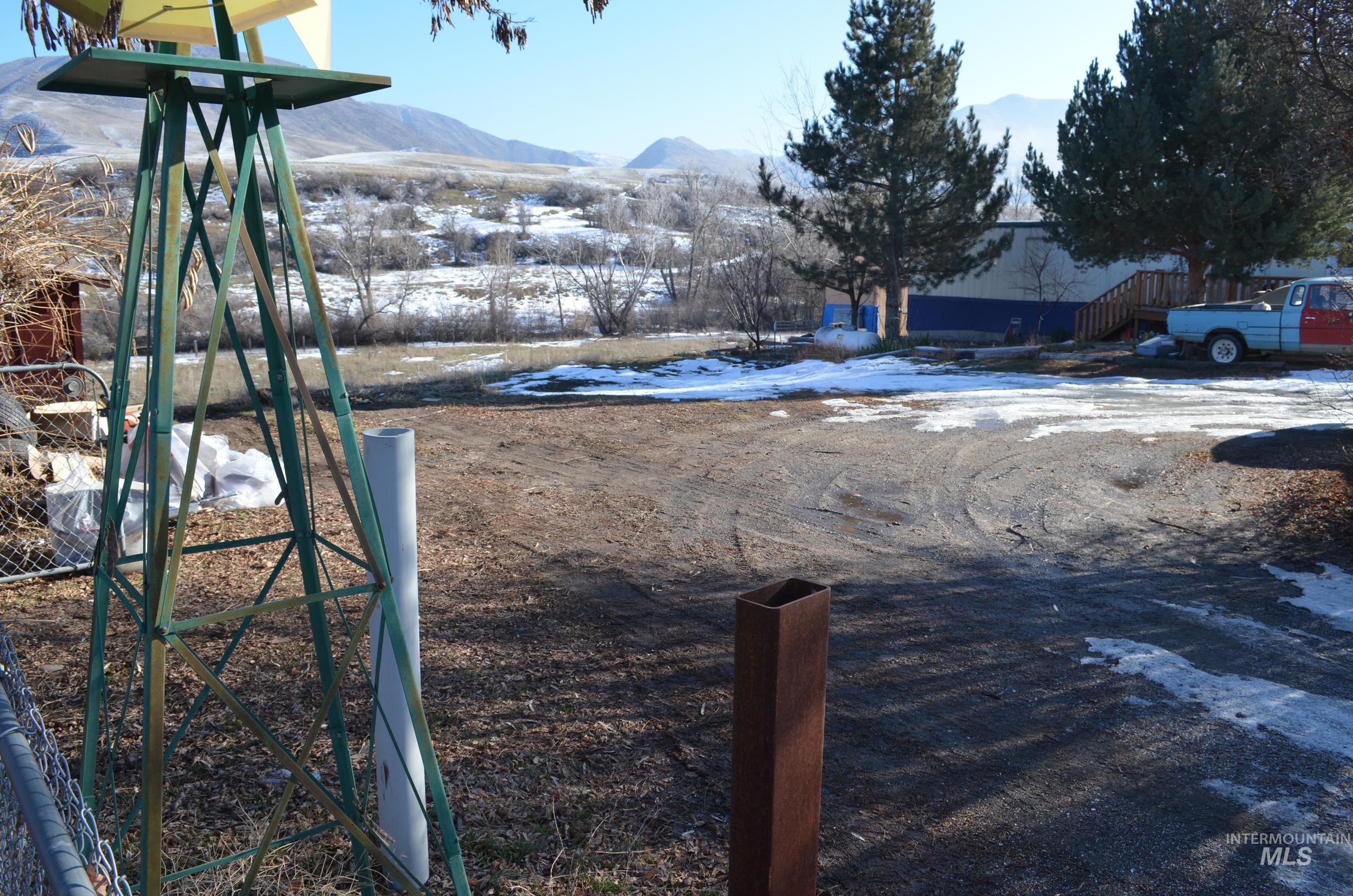 Yard layered in snow with a mountain view