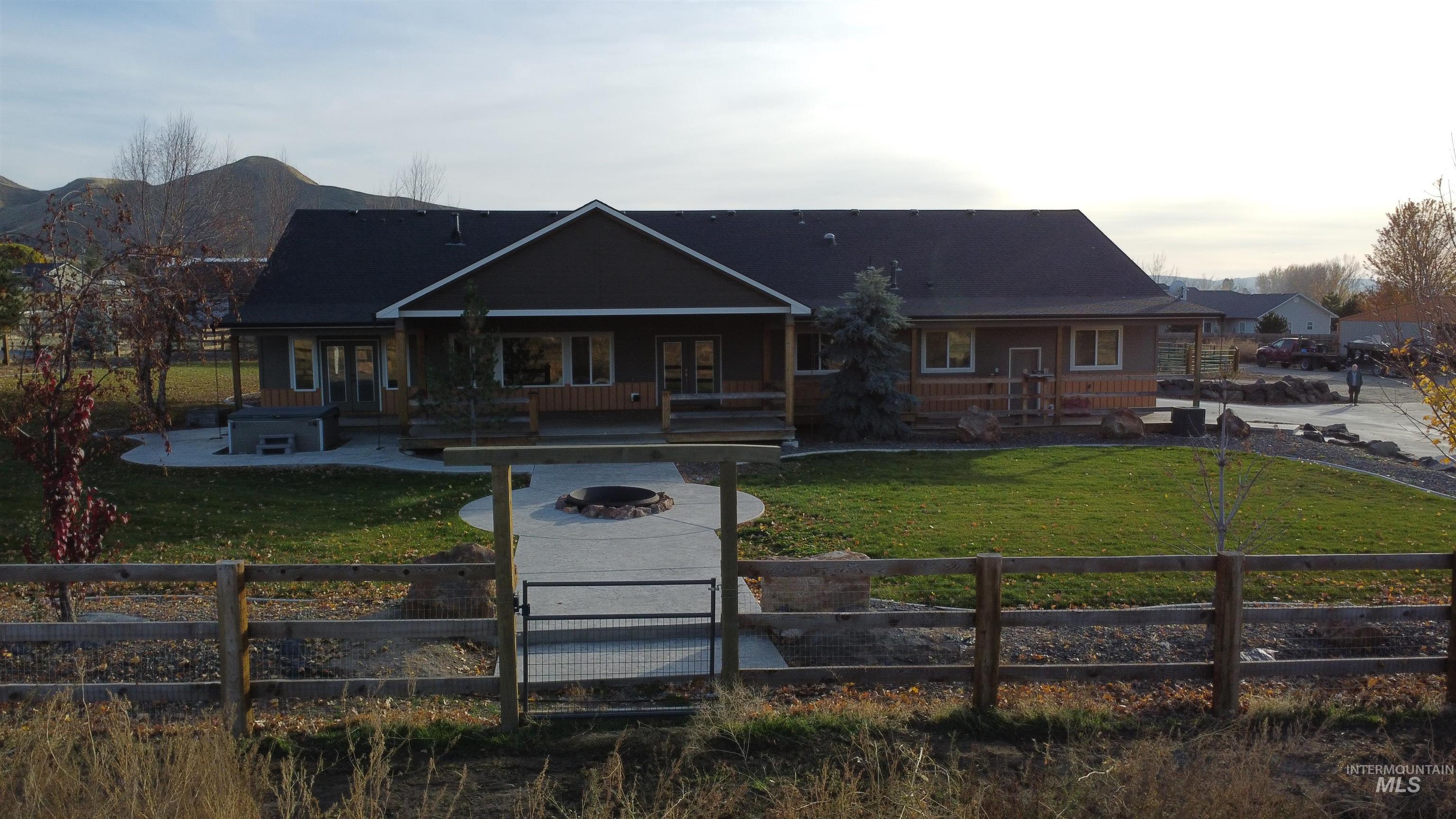 View of front of house featuring a patio, a fire pit, a fenced front yard, and a gate