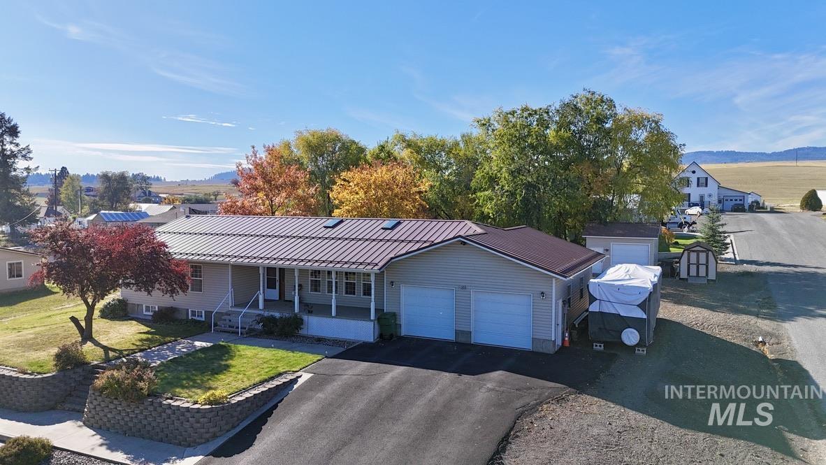 Single story home featuring covered porch, a front yard, driveway, and an attached garage