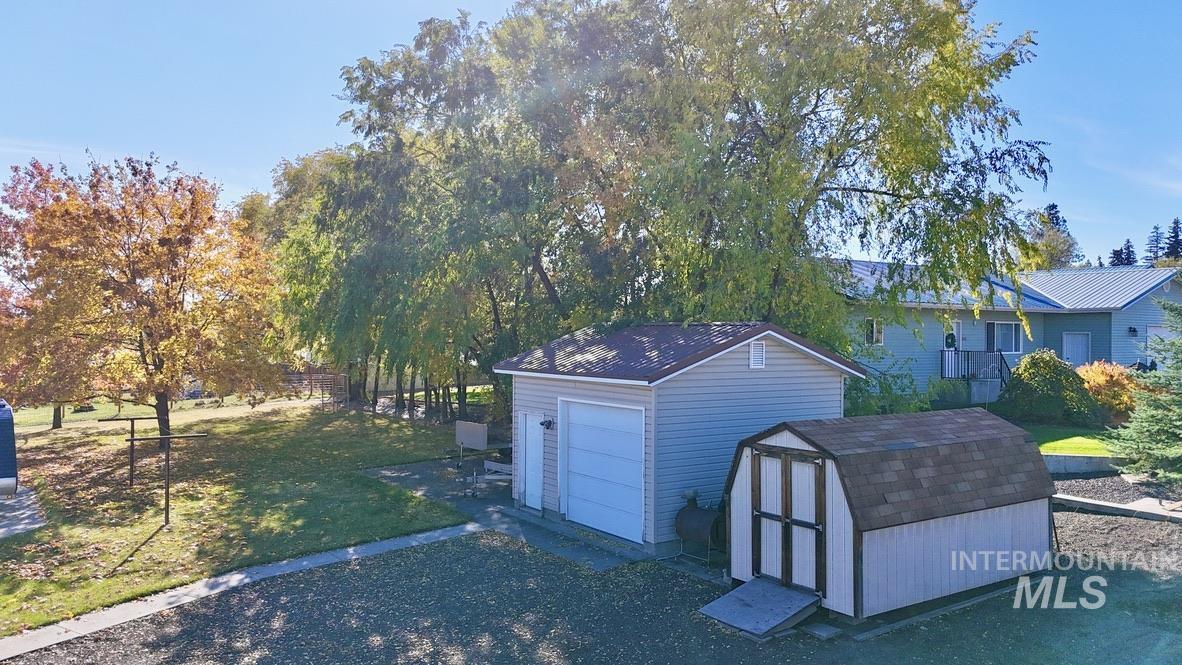 Detached garage featuring a storage unit and driveway