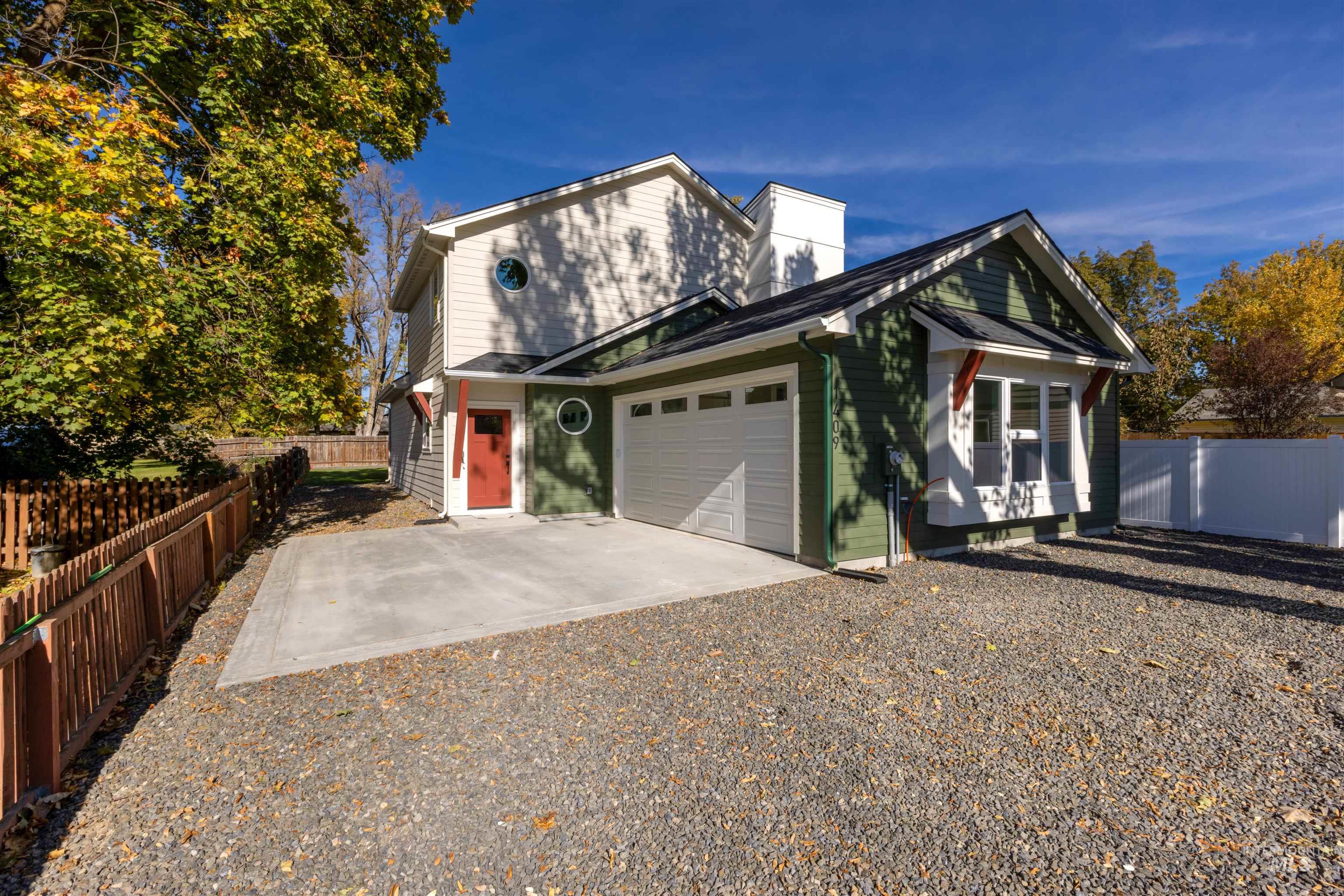 View of front of home featuring driveway, an attached garage, and a chimney