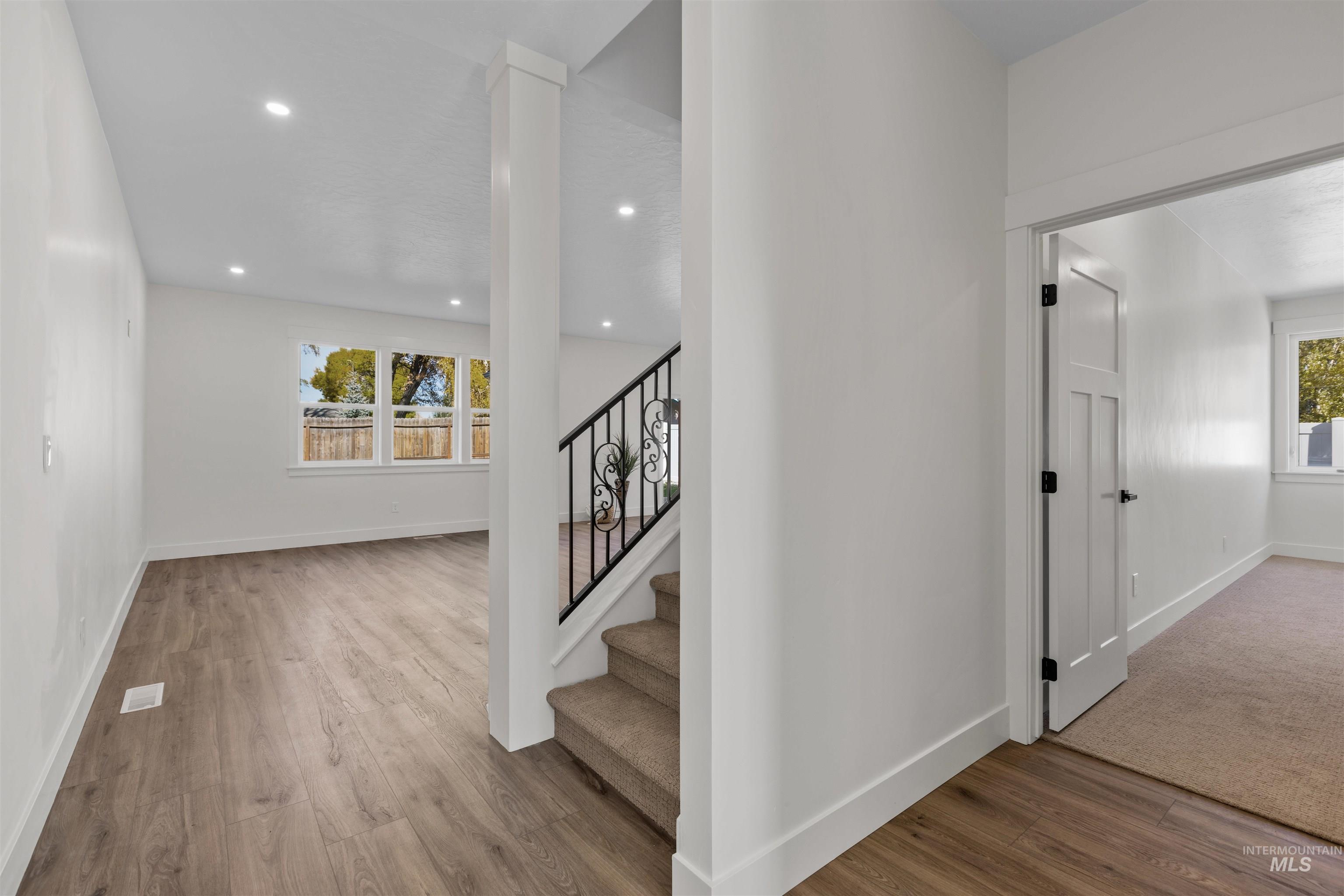 Staircase featuring wood finished floors and recessed lighting