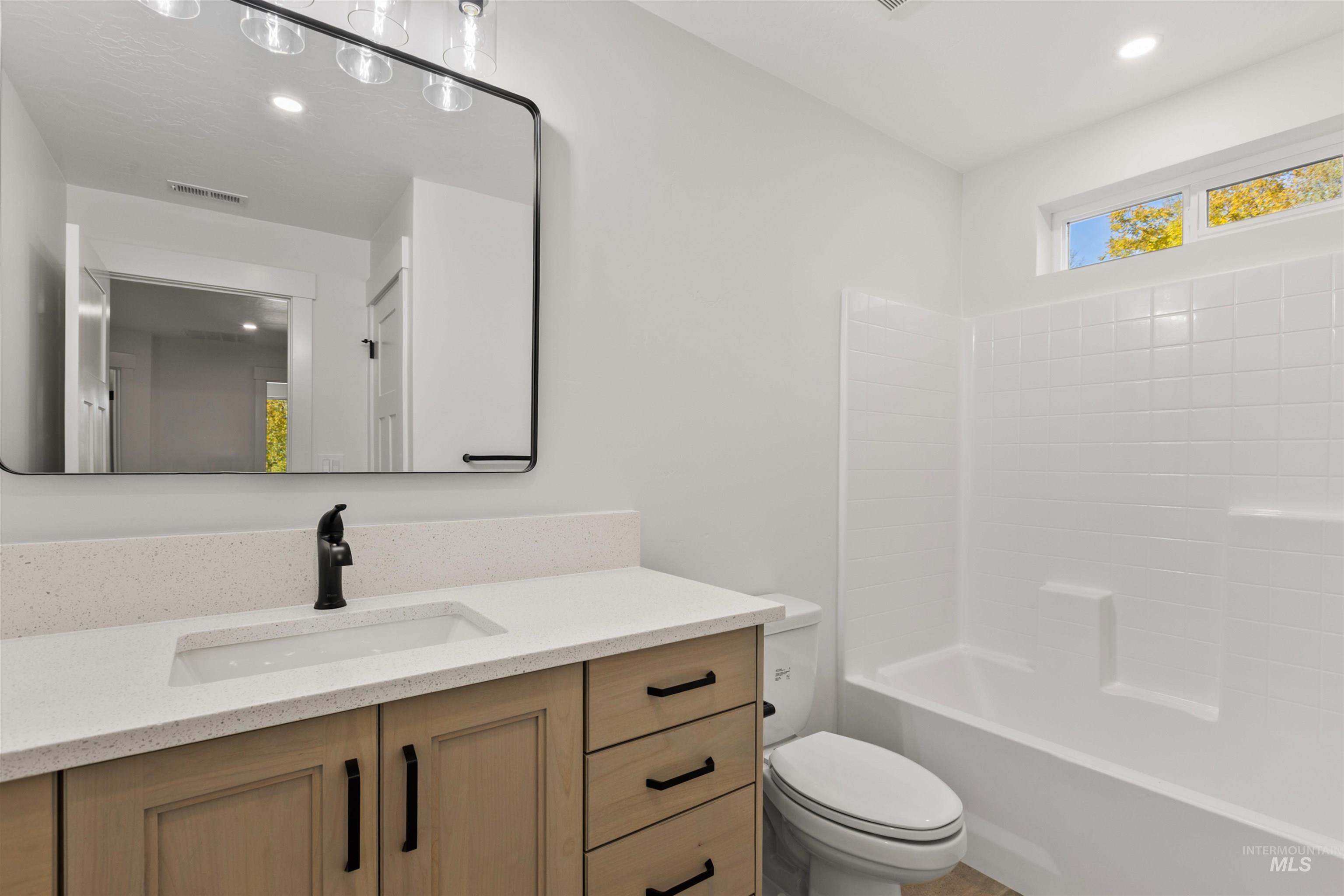 Bathroom featuring vanity, bathtub / shower combination, and recessed lighting