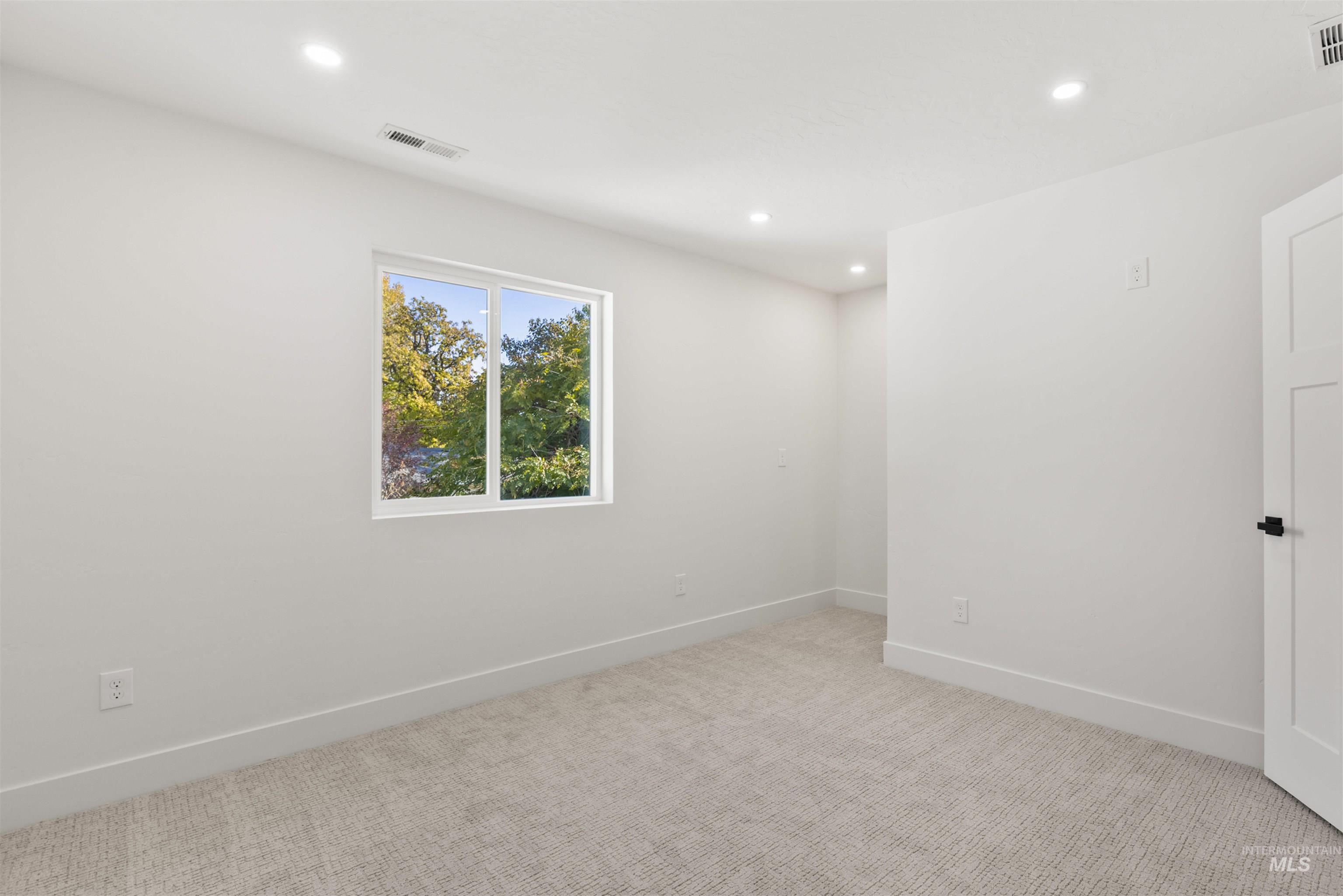 Spare room with light carpet and recessed lighting