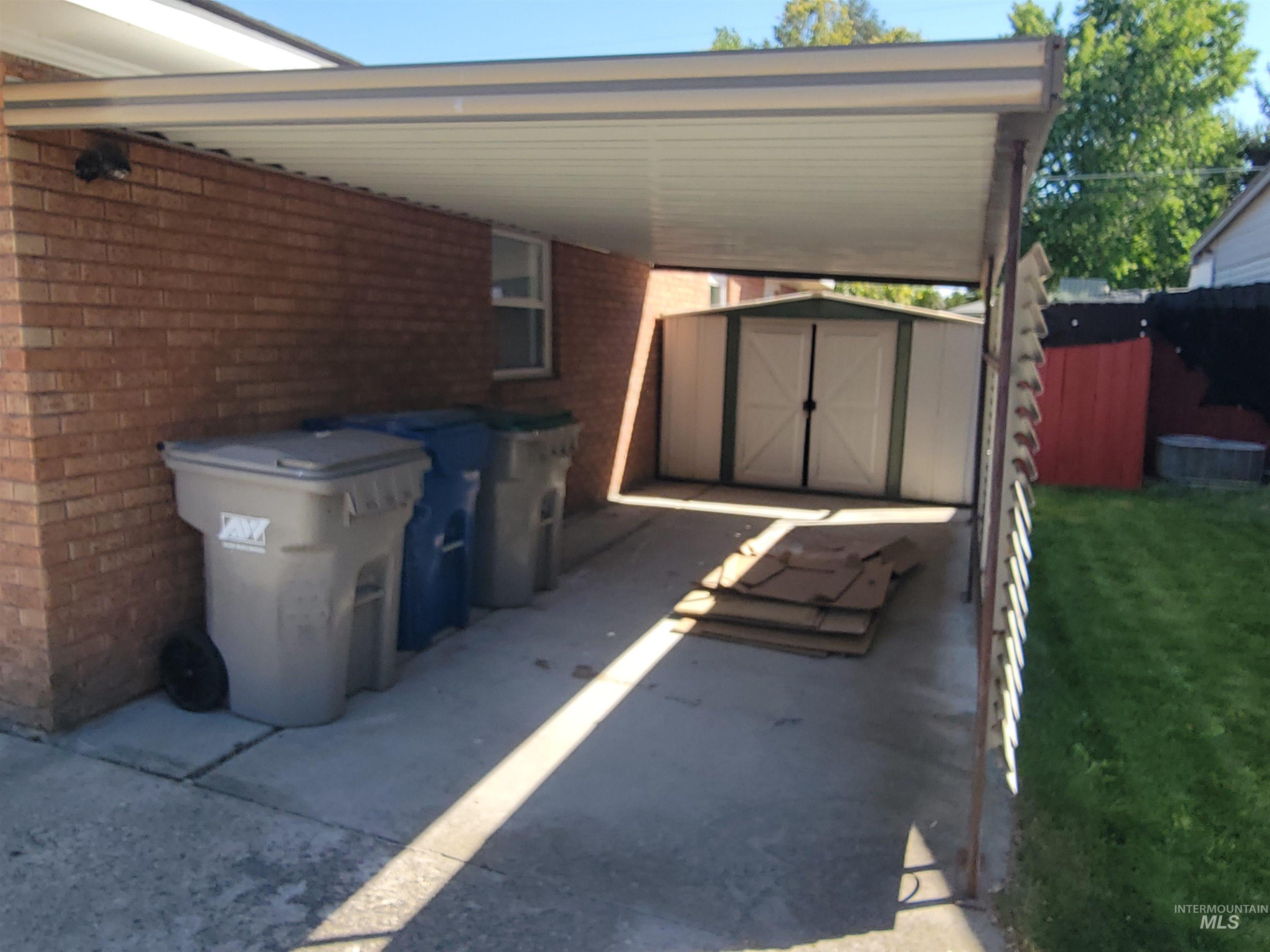 View of patio / terrace featuring a storage shed and an attached carport