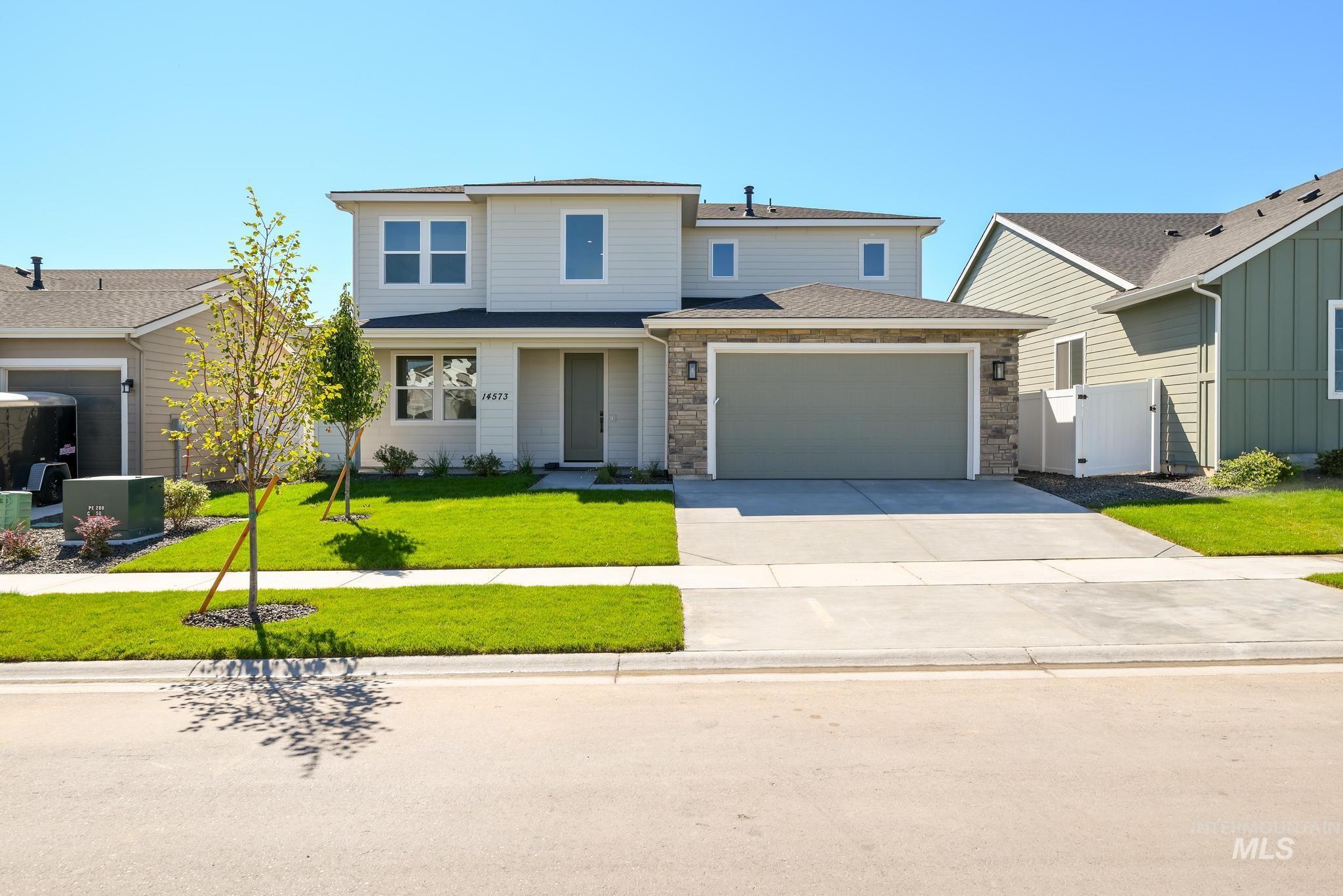 Traditional home with concrete driveway, a garage, and roof with shingles