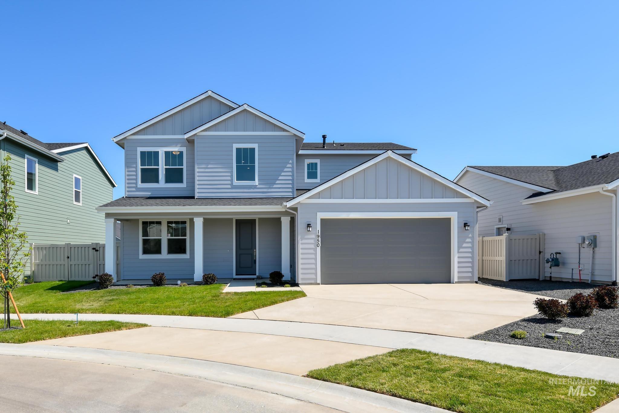 View of front of property with board and batten siding, a gate, covered porch, and concrete driveway