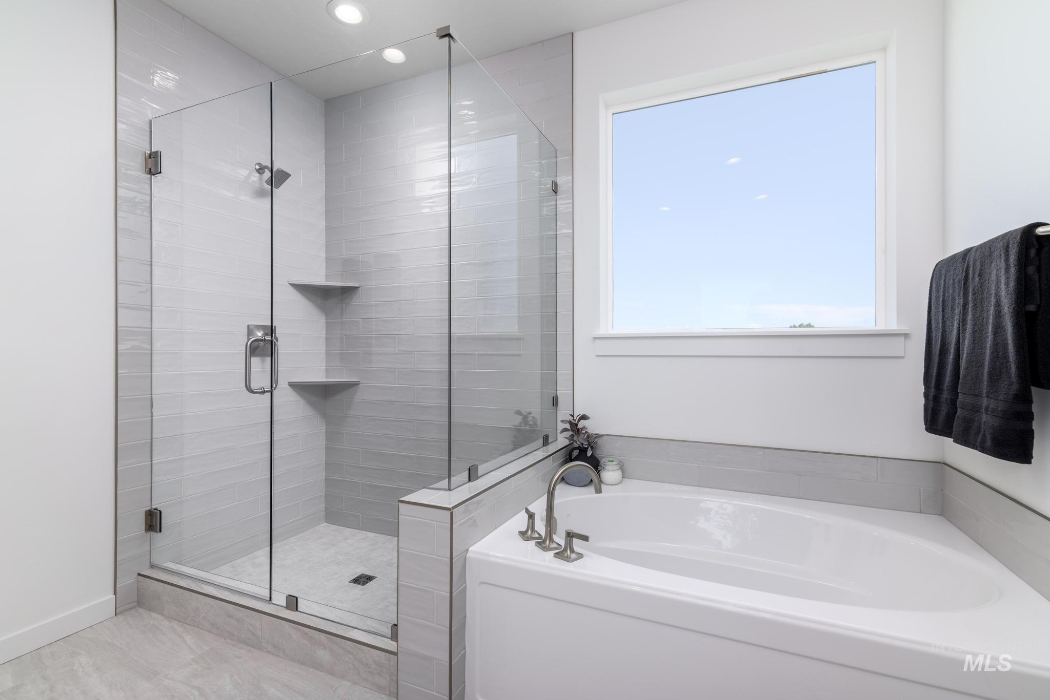 Bathroom with plenty of natural light, a bath, recessed lighting, and a stall shower