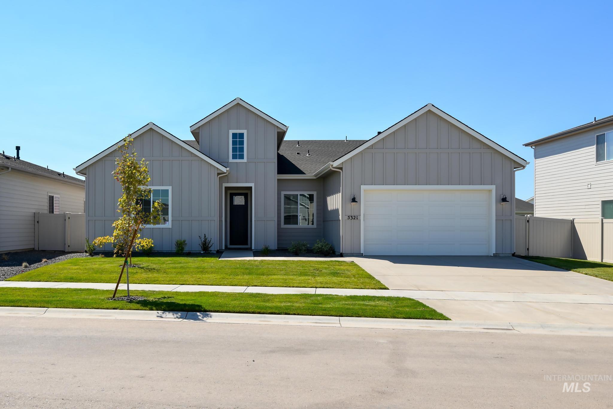 View of front facade with board and batten siding, concrete driveway, and a garage