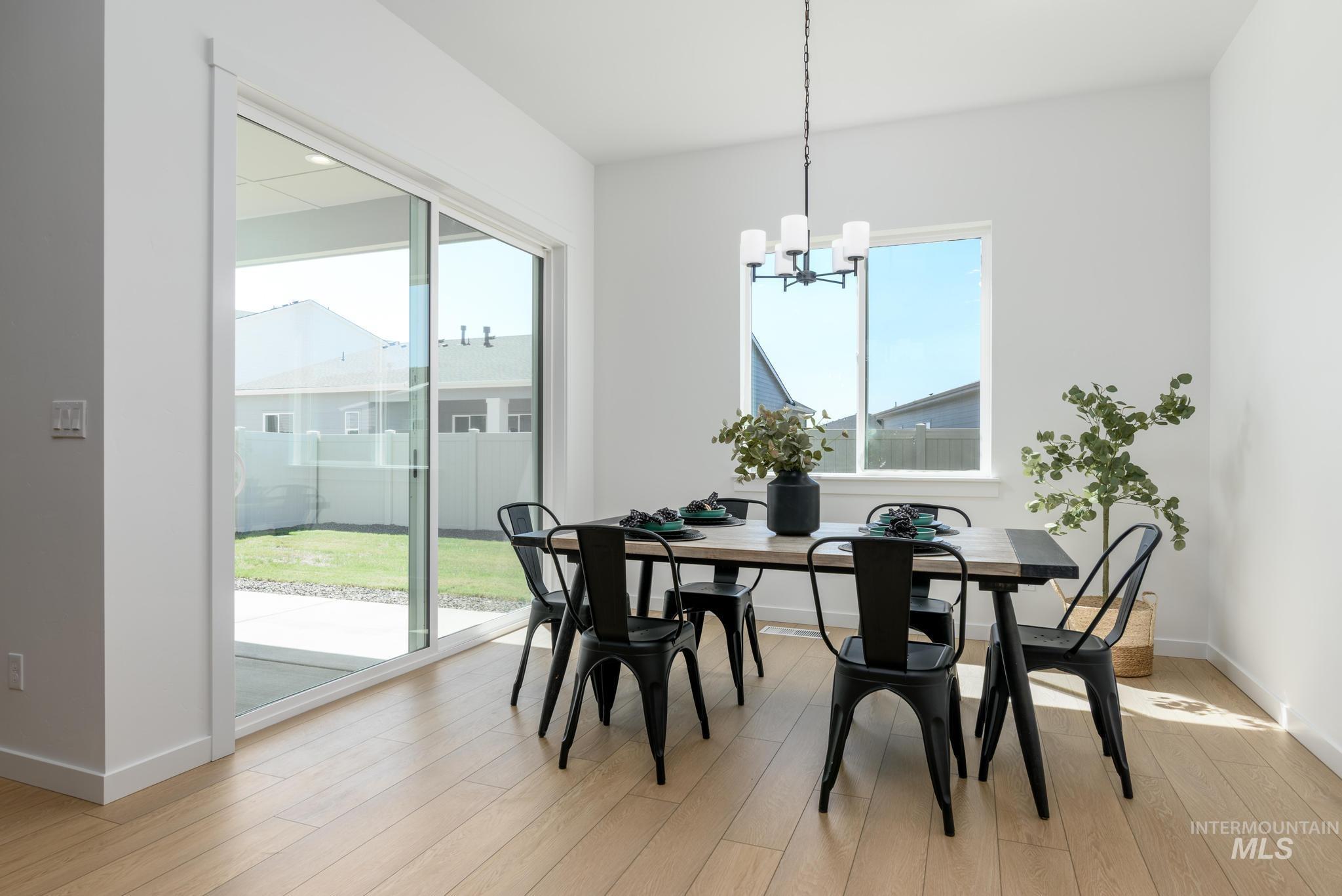 Dining room with light wood-style flooring and a chandelier