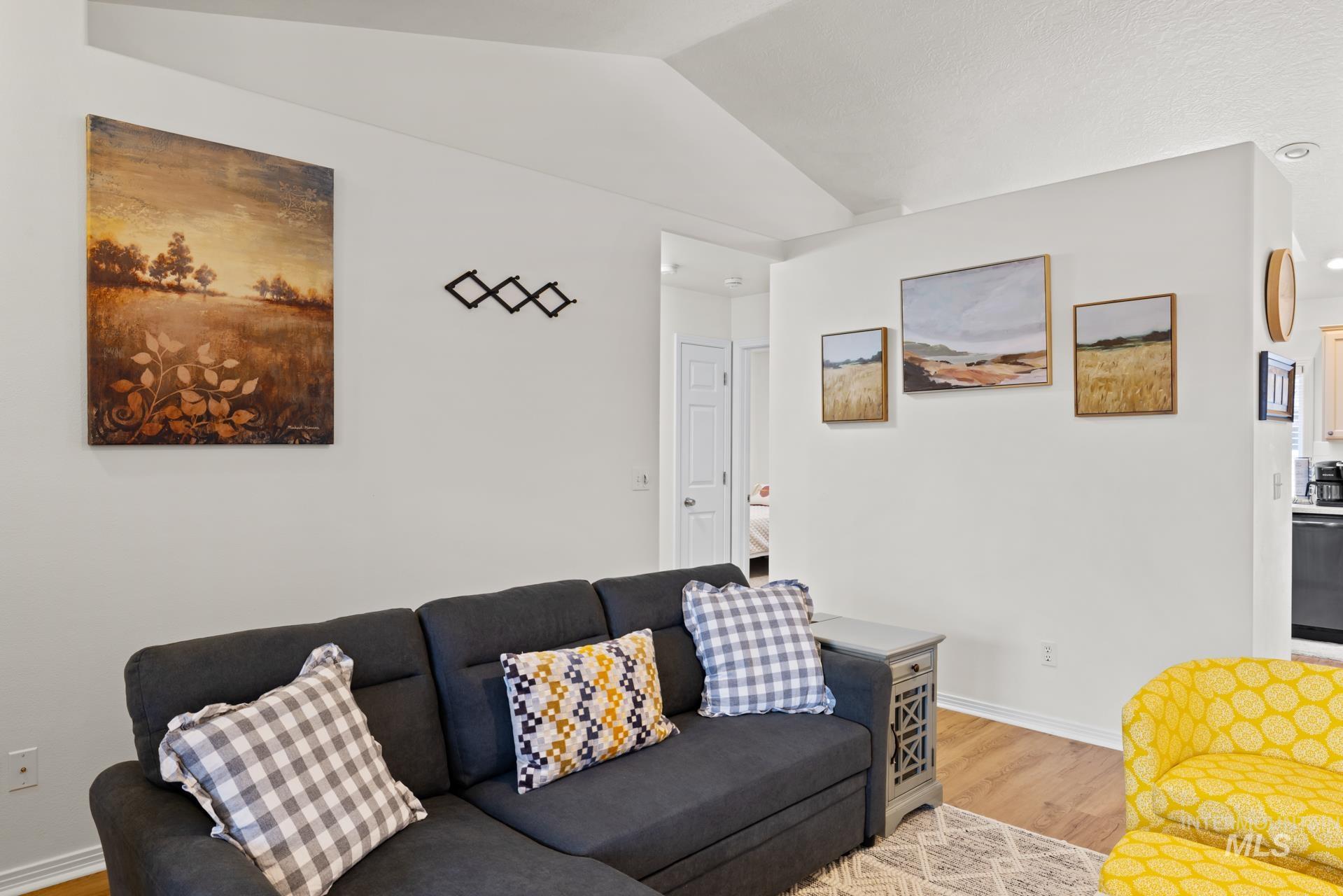 Living room featuring light wood-style floors and vaulted ceiling