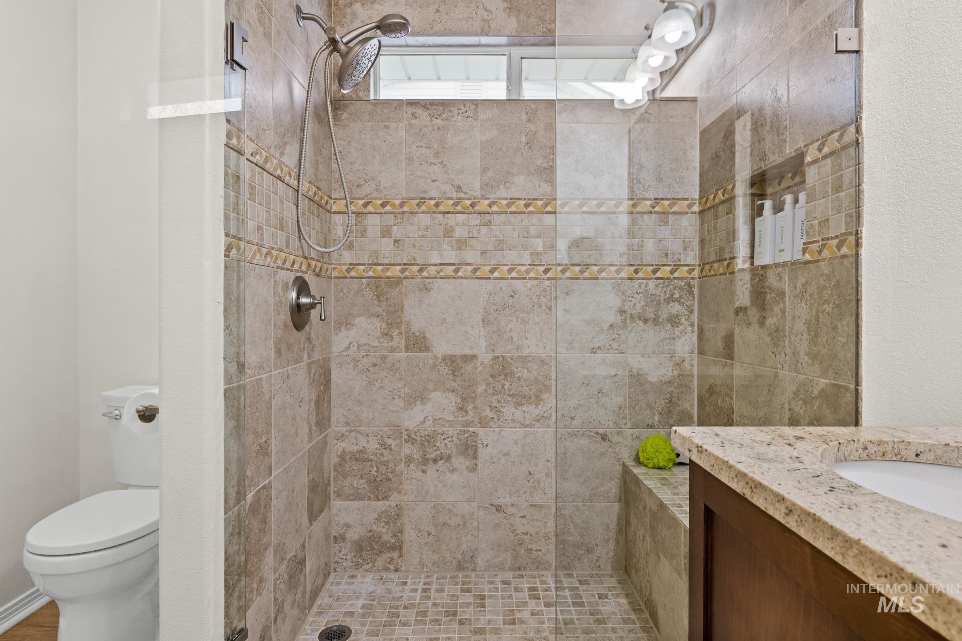 Full bathroom with vanity and tiled shower