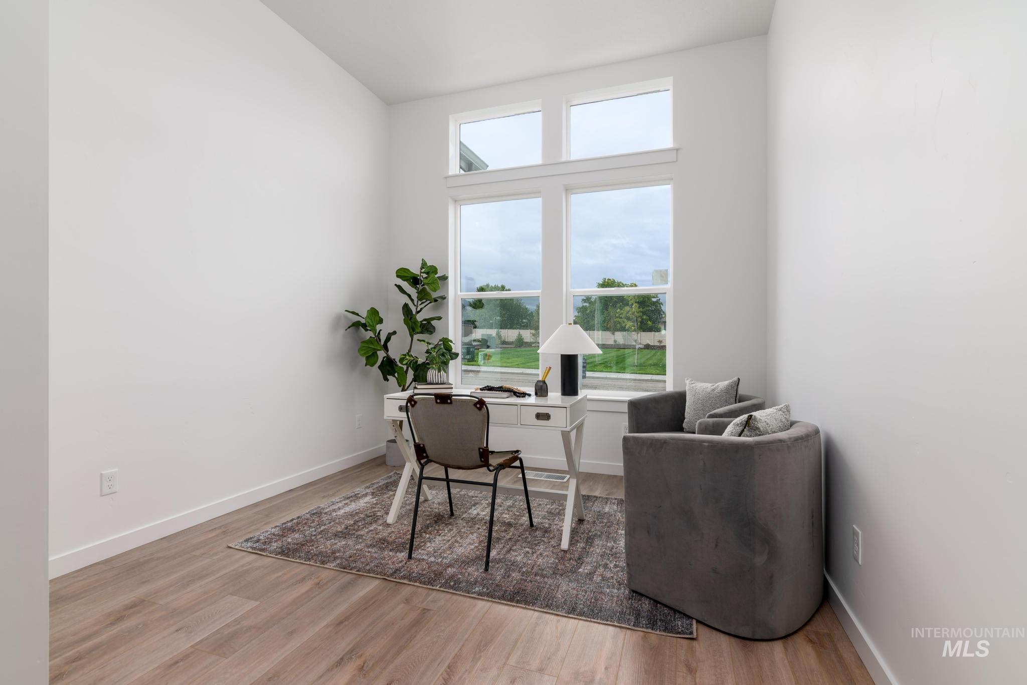 Home office featuring light wood-type flooring and baseboards
