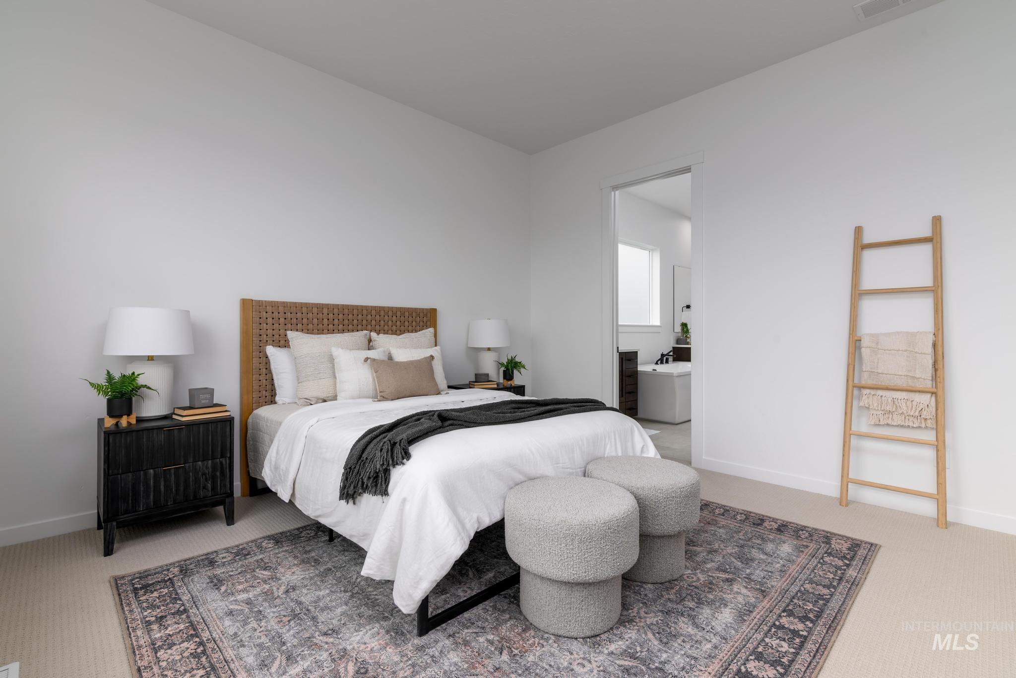 Bedroom featuring light colored carpet and ensuite bathroom