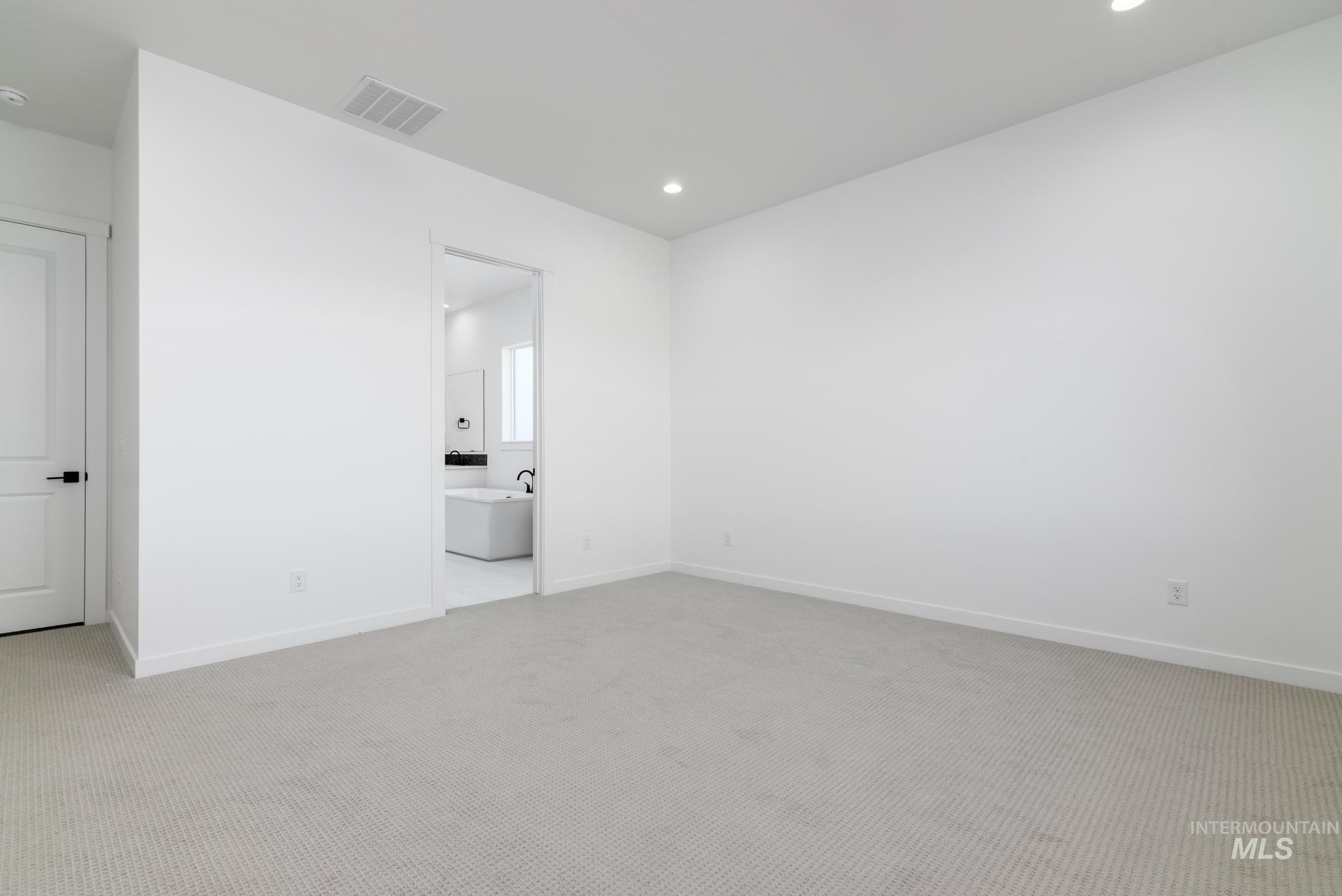 Spare room with light colored carpet and recessed lighting