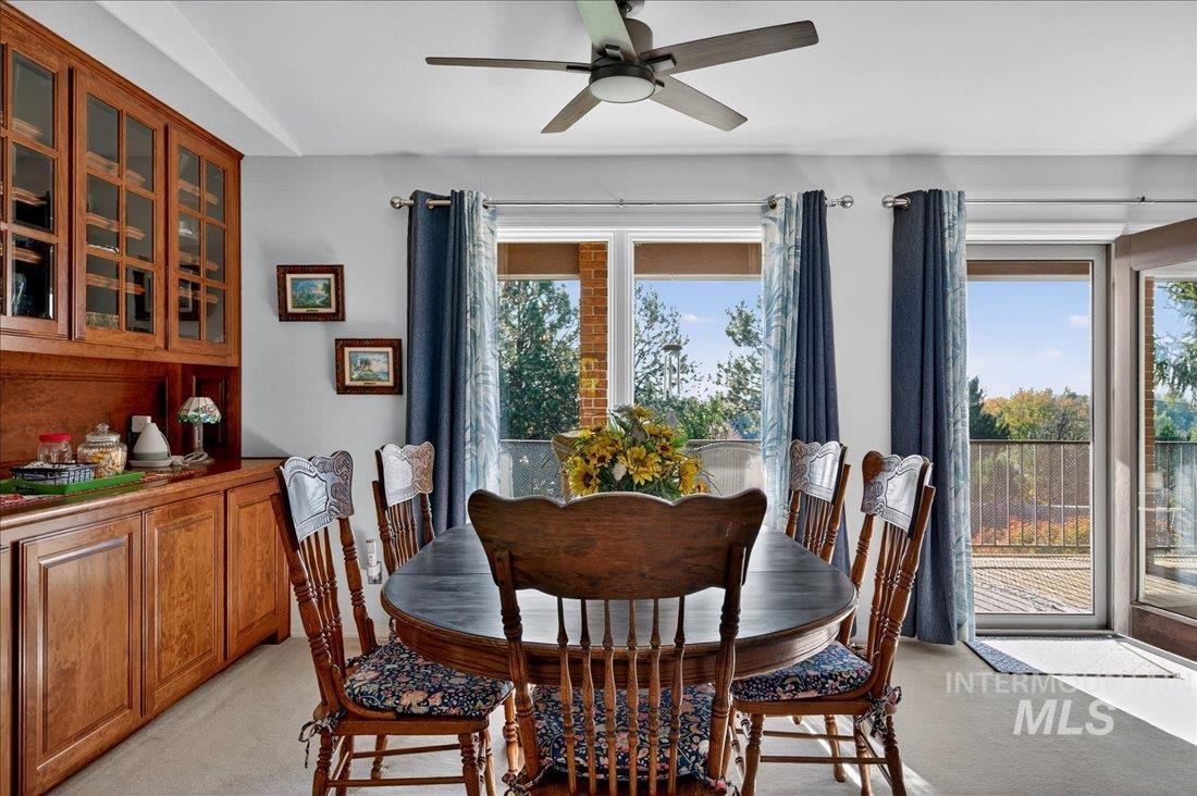 Dining room with light carpet and ceiling fan