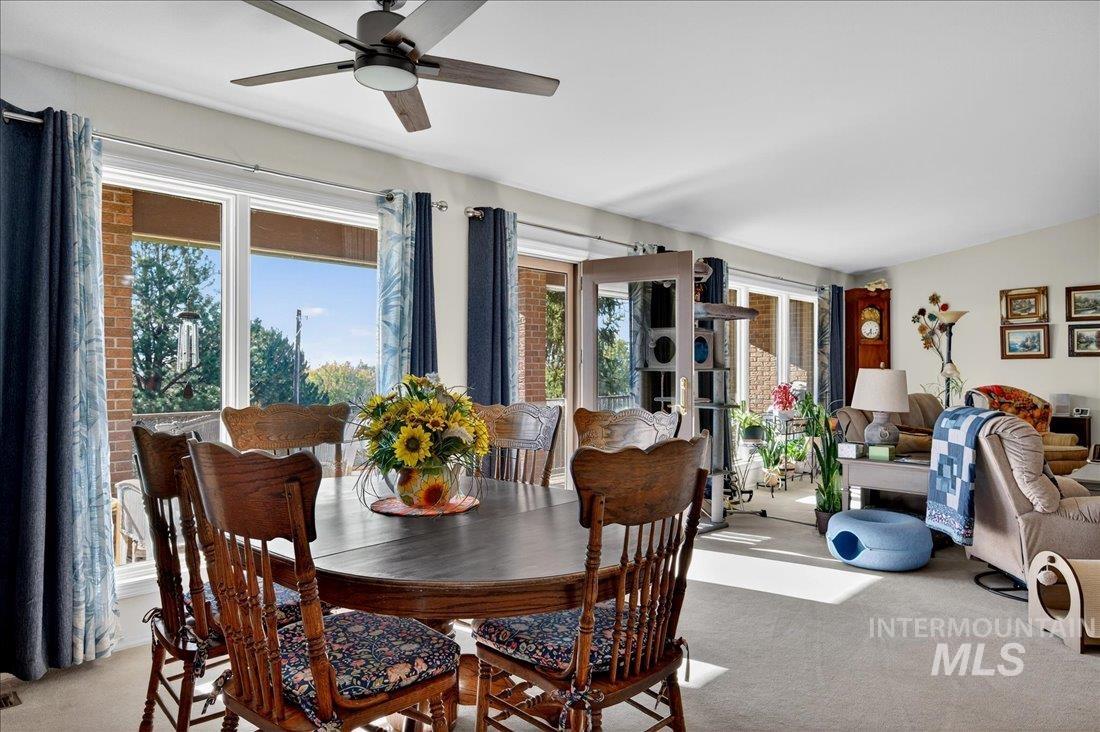 Dining room with light carpet and ceiling fan