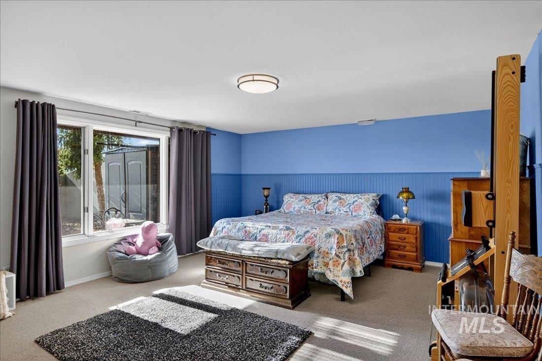 Carpeted bedroom with wainscoting and baseboards